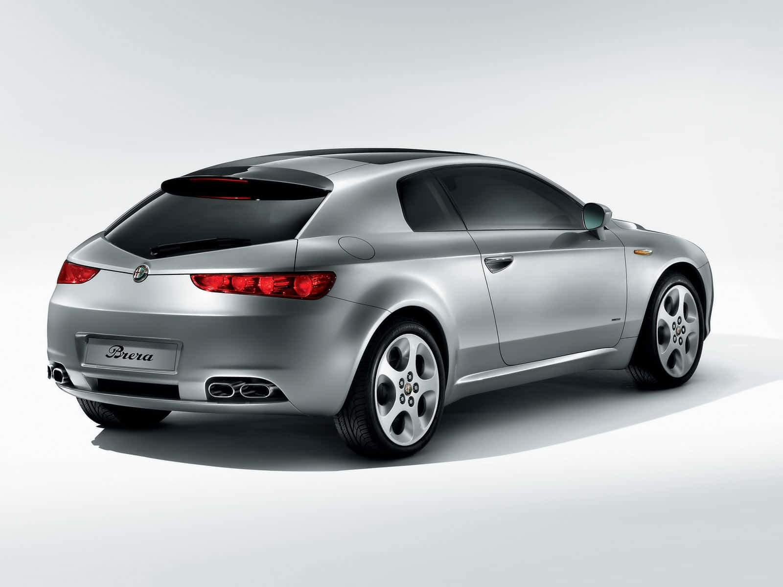 Alfa Romeo Brera 桌布 壁紙 — 一輛時尚的銀色愛快羅密歐Brera運動轎跑車，以四分之三後視角度呈現，背景為簡約的白色攝影棚。
