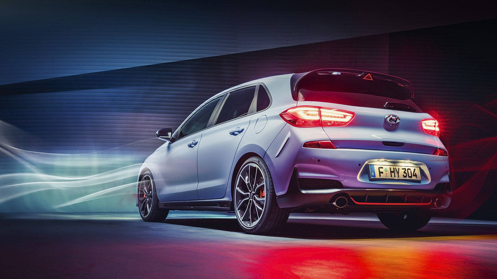 Hyundai 桌布 壁紙 — 一輛時尚的銀色掀背車，帶有發光的紅色尾燈，在黑暗的隧道中高速行駛，留下模糊的運動軌跡。