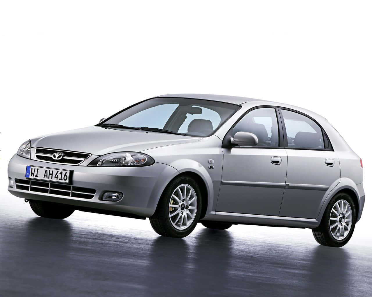 Daewoo 桌布 壁紙 — 一輛時尚的銀色掀背車在攝影棚內拍攝，配有反射地板和純白背景。