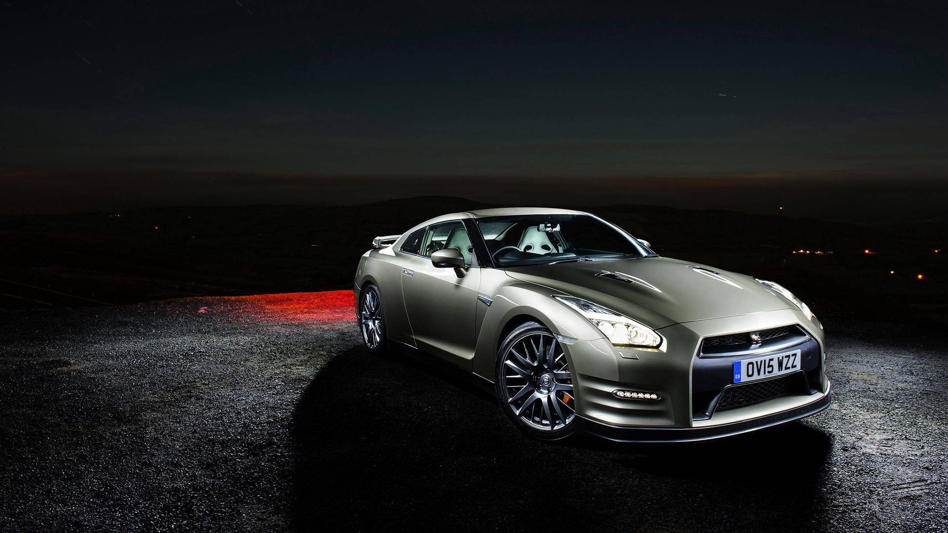 銀色跑車夜間停放，背景有紅色光芒和城市燈光。 — Toyota Supra Mk4 壁紙