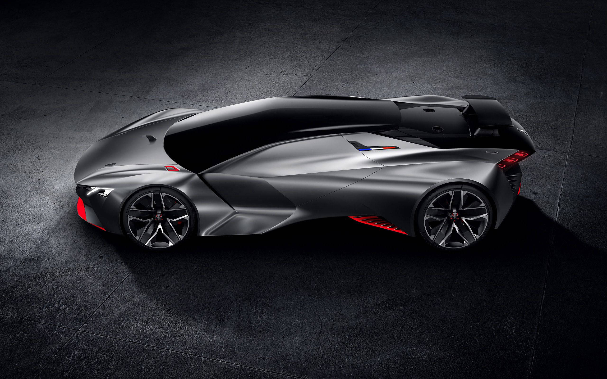 Peugeot 桌布 壁紙 — 一輛時尚的銀色未來主義跑車帶有紅色點綴，在戲劇性的工作室燈光下停放在深色混凝土地板上。