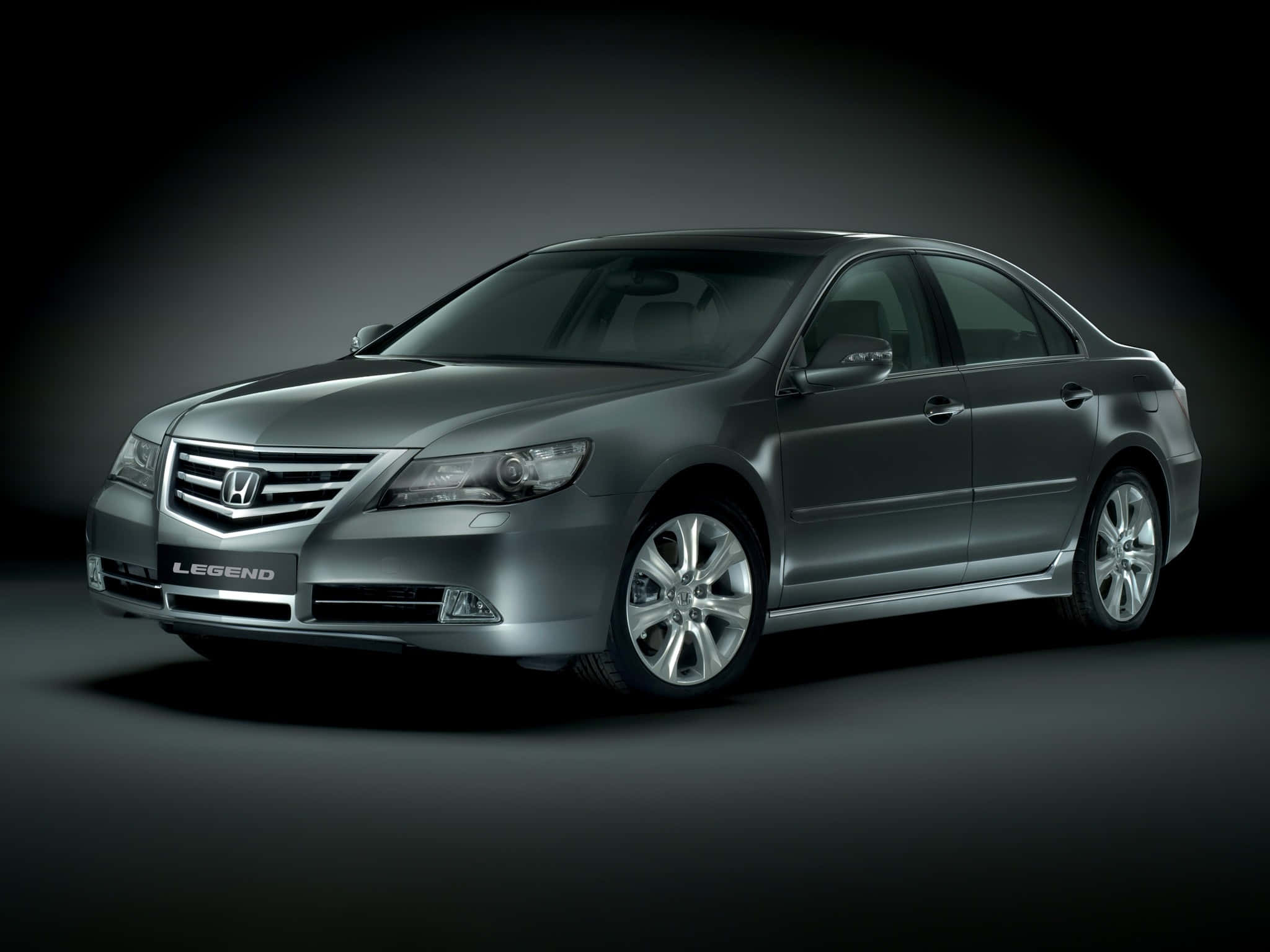 Honda Legend 桌布 壁紙 — 一輛時尚的銀色本田Legend轎車在攝影棚燈光下，在深色漸變背景上閃閃發光。