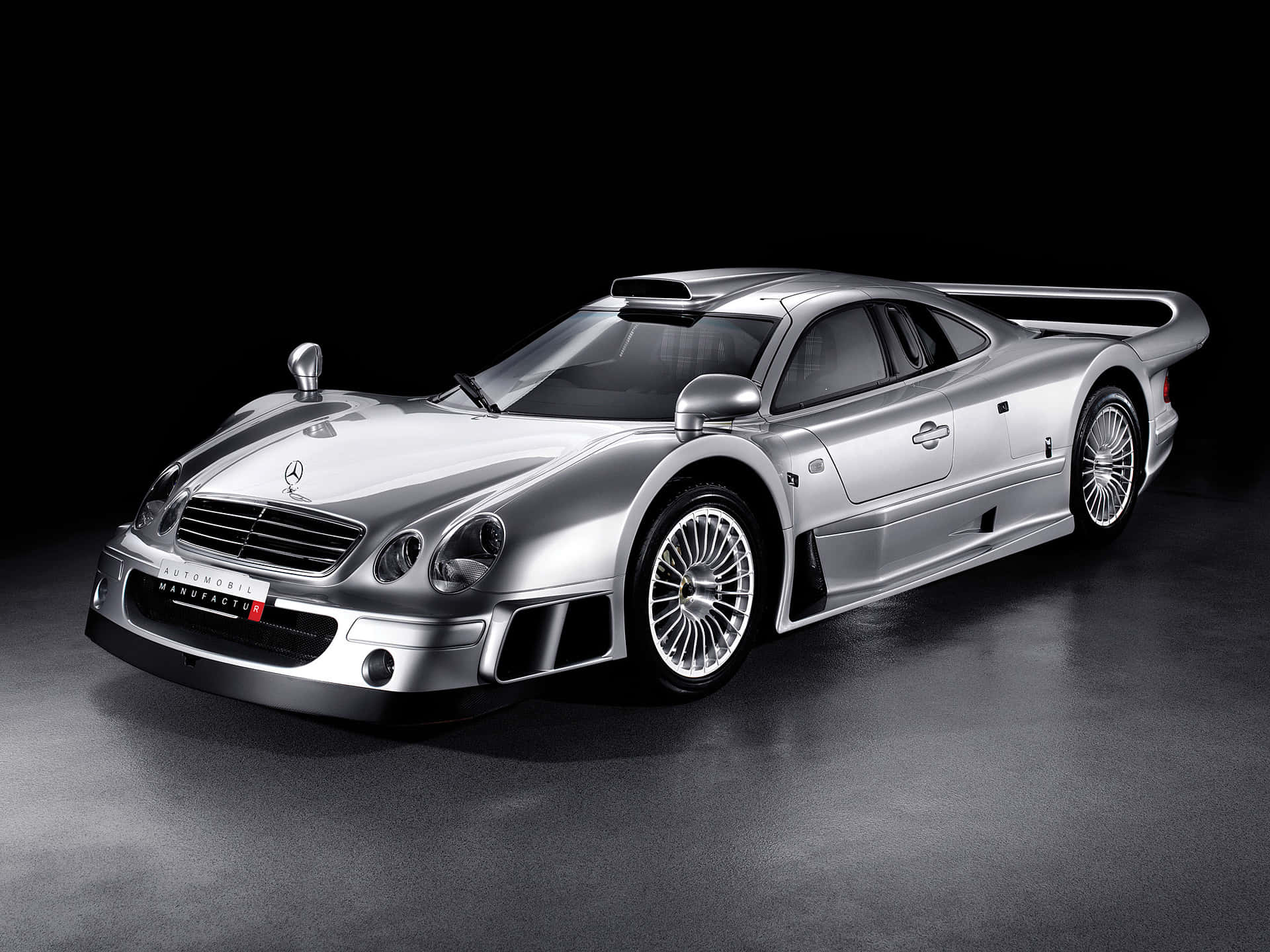 Gtr 桌布 壁紙 — 一輛時尚的銀色梅賽德斯-奔馳 CLK GTR 賽車在黑色背景下於攝影棚燈光中閃耀。
