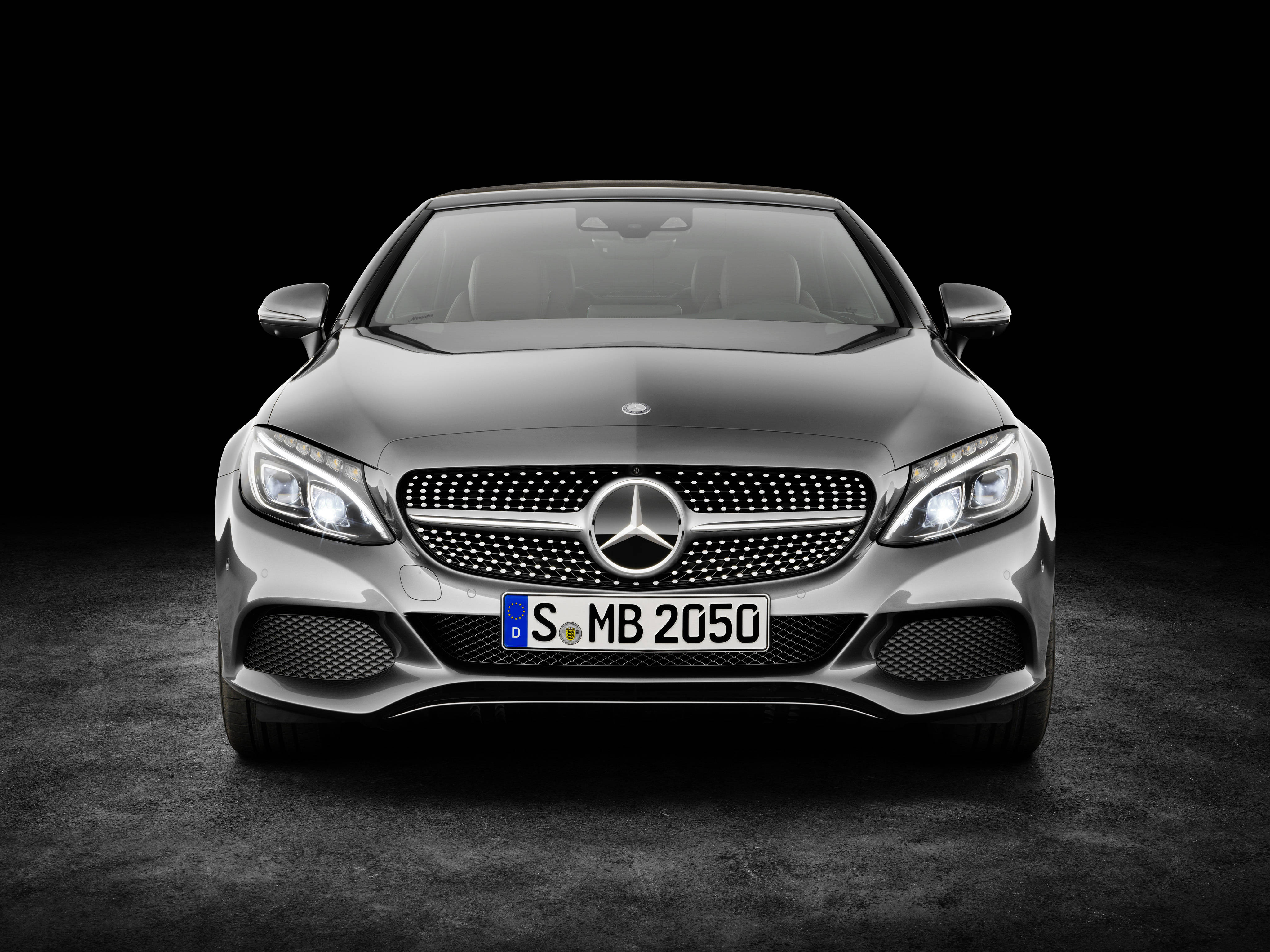 benz 4K 桌布 壁紙 — 一輛時尚的銀色梅賽德斯-奔馳S-Class轎跑車在攝影棚燈光下，在純黑背景上閃耀。