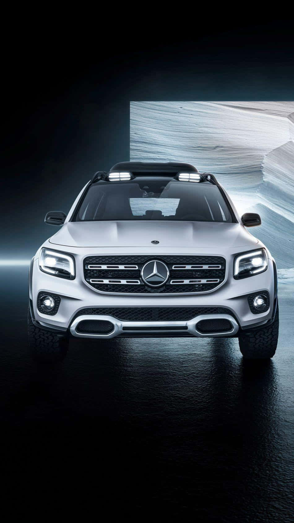 Mercedes 桌布 壁紙 — 一輛時尚的銀色梅賽德斯-奔馳SUV在戲劇性的攝影棚燈光下正面朝前，配備發光的頭燈和反射性的濕地板。