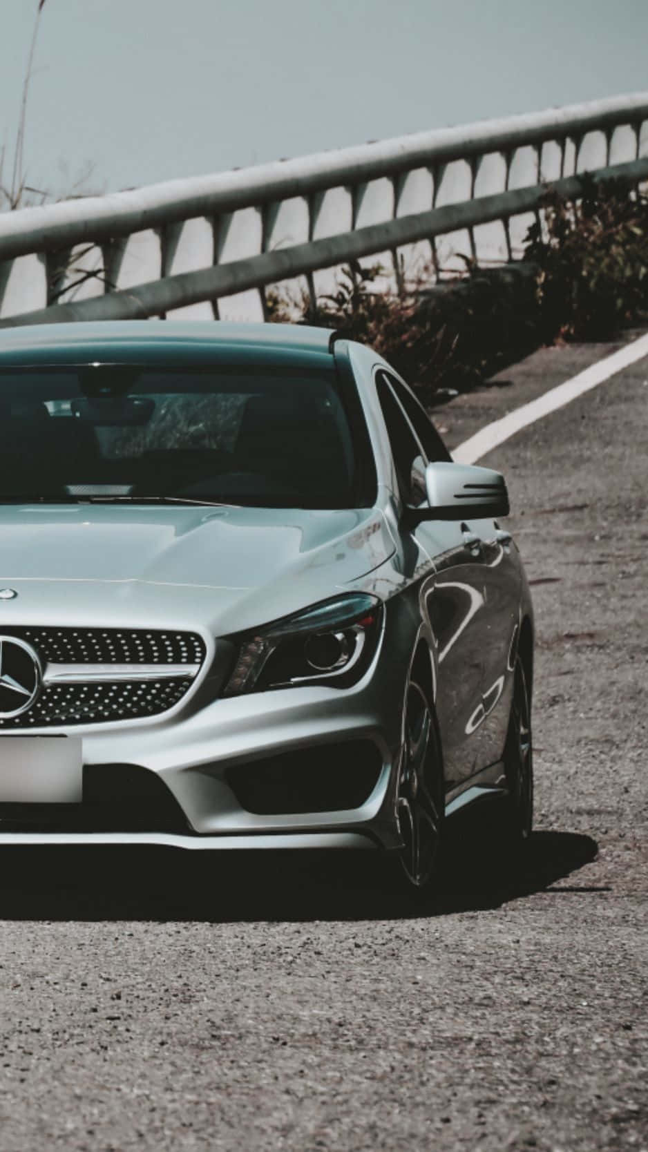 Mercedes 桌布 壁紙 — 一輛時尚的銀色梅賽德斯-奔馳跑車停泊在蜿蜒的山路上，背景有護欄。
