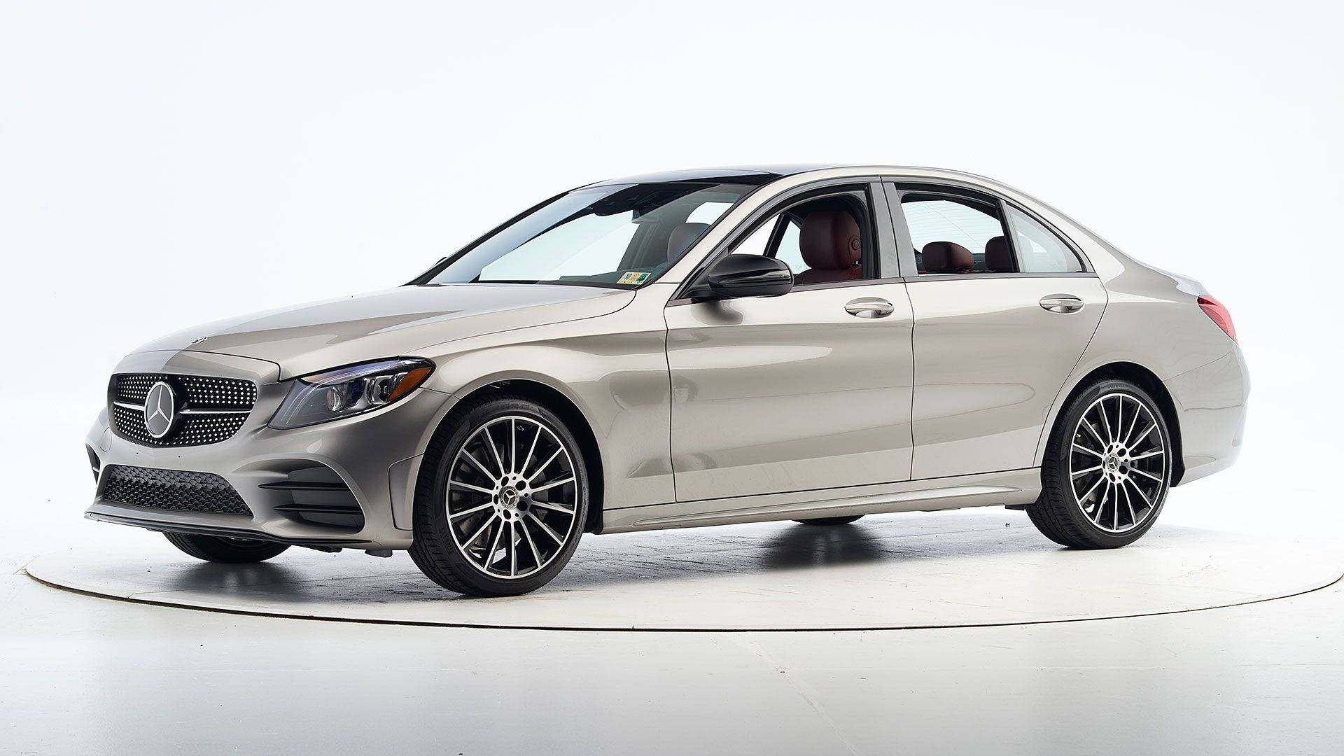 Mercedes Benz C300 桌布 壁紙 — 一輛時尚的銀色梅賽德斯-奔馳轎車在明亮的攝影棚中展示，配有潔白的白色地板和背景。