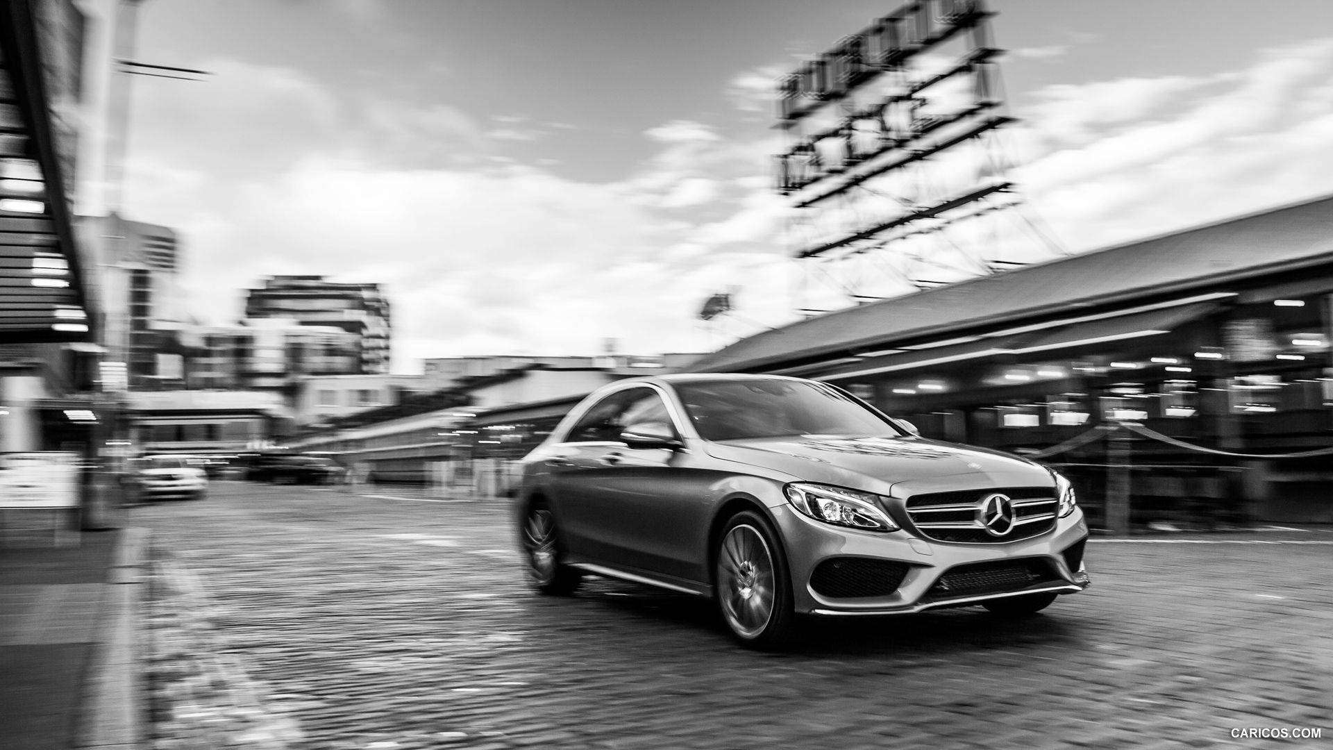 Mercedes Benz C300 桌布 壁紙 — 一輛時尚的銀色梅賽德斯轎車在模糊的城市街道上疾馳，動態模糊強調了其動態運動。