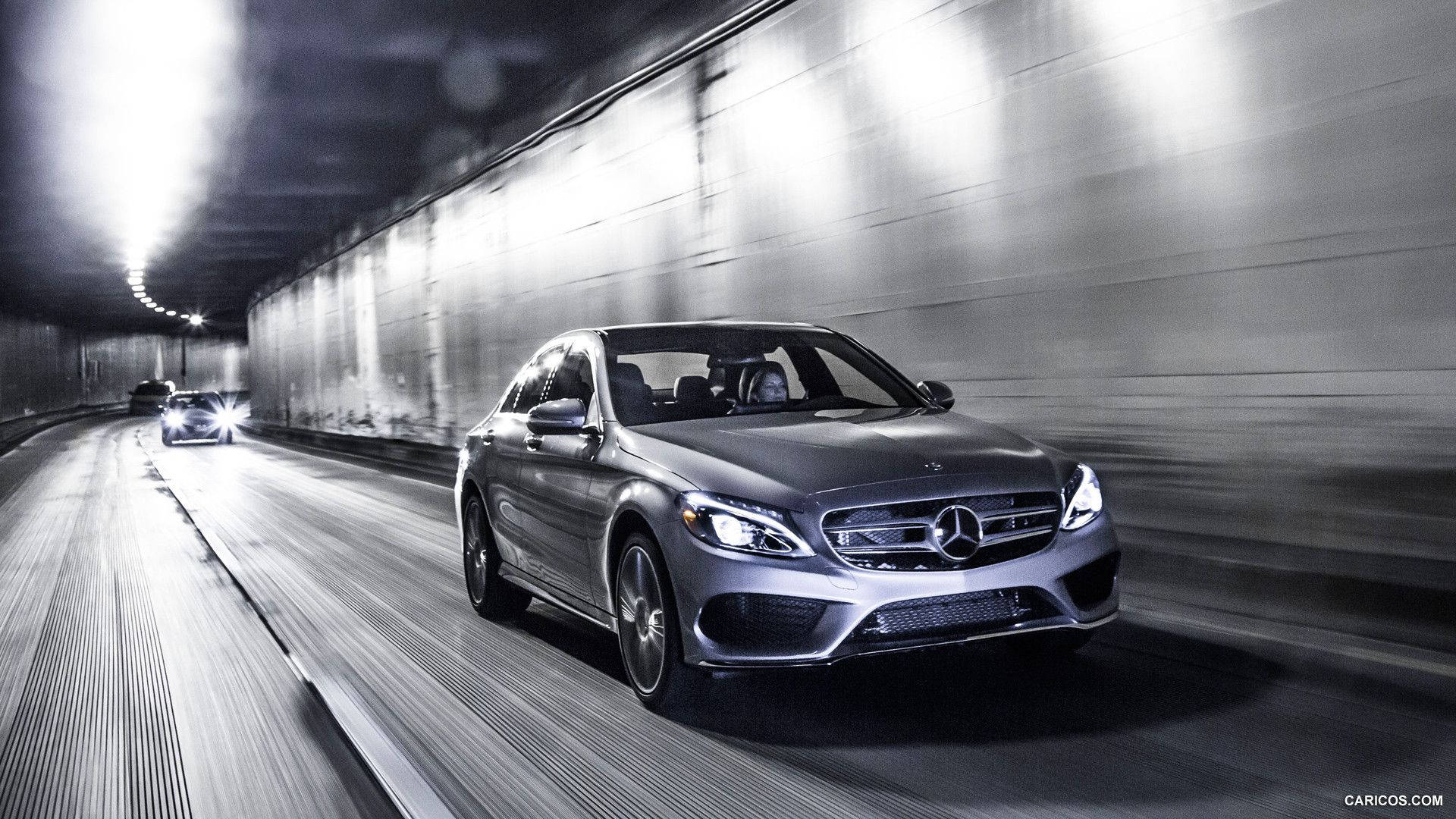 Mercedes Benz C300 桌布 壁紙 — 一輛時尚的銀色梅賽德斯轎車在隧道中疾馳，動態模糊強調了速度和現代設計。