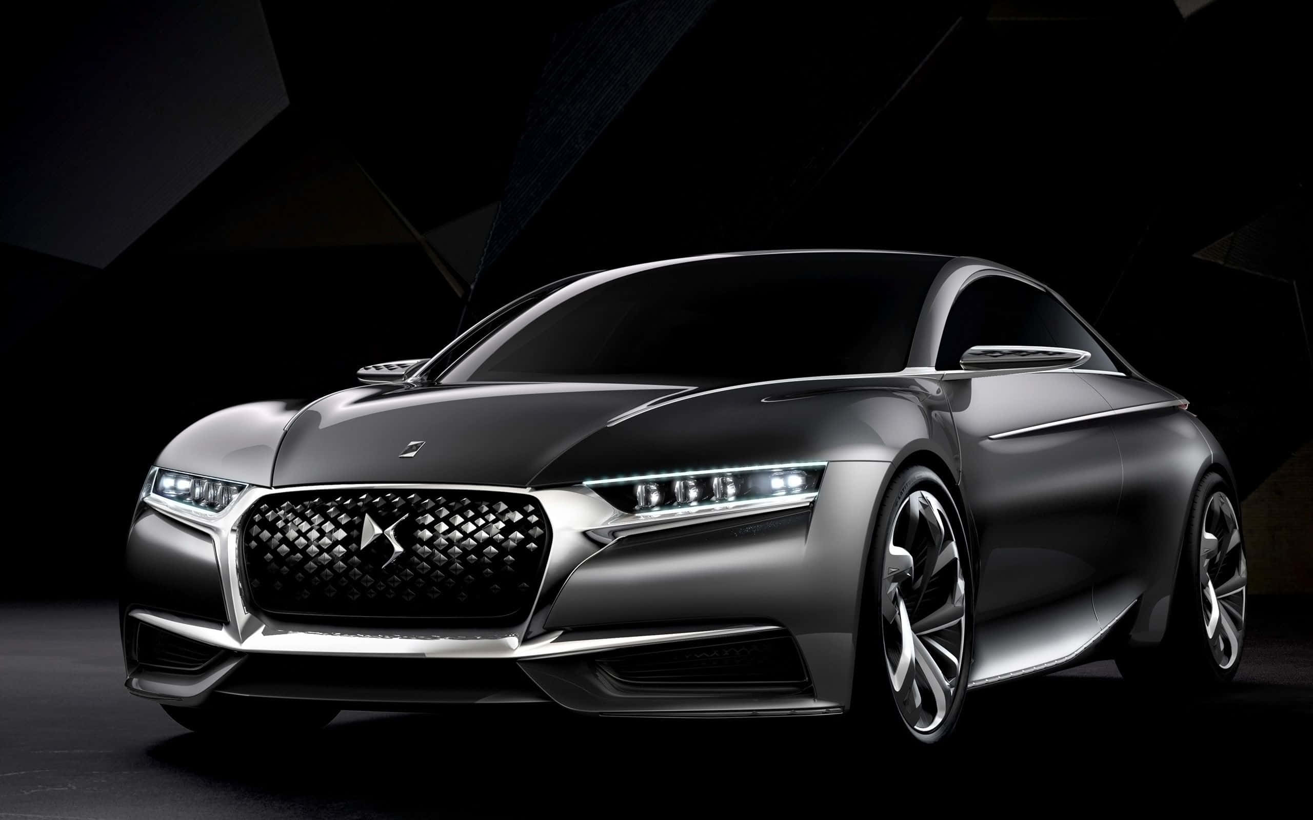 Ds Automobiles 桌布 壁紙 — 一輛時尚的銀色概念車，帶有發光的車頭燈和幾何暗色背景。