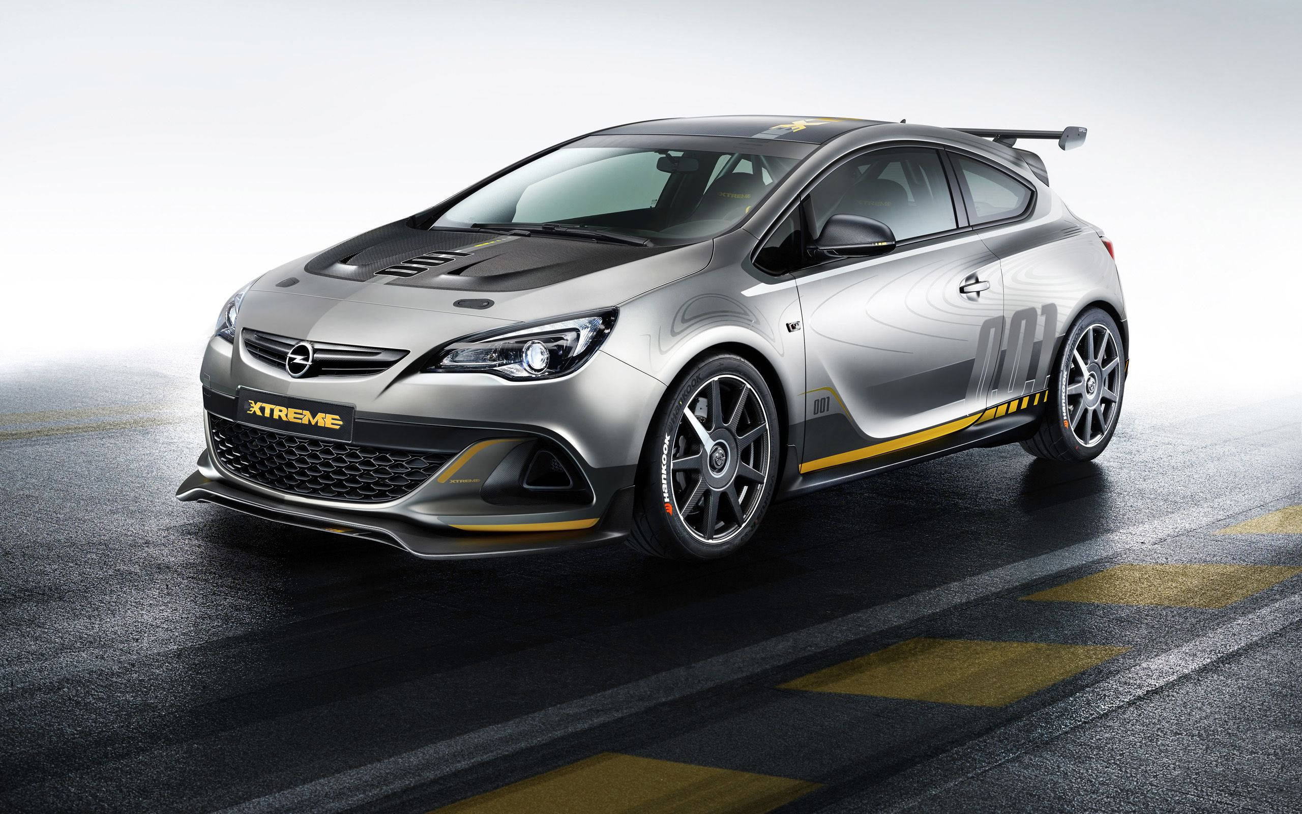 Opel 桌布 壁紙 — 一輛時尚的銀色歐寶賽車，帶有黃色點綴和「XTREME」品牌，停在潮濕的賽道表面上。