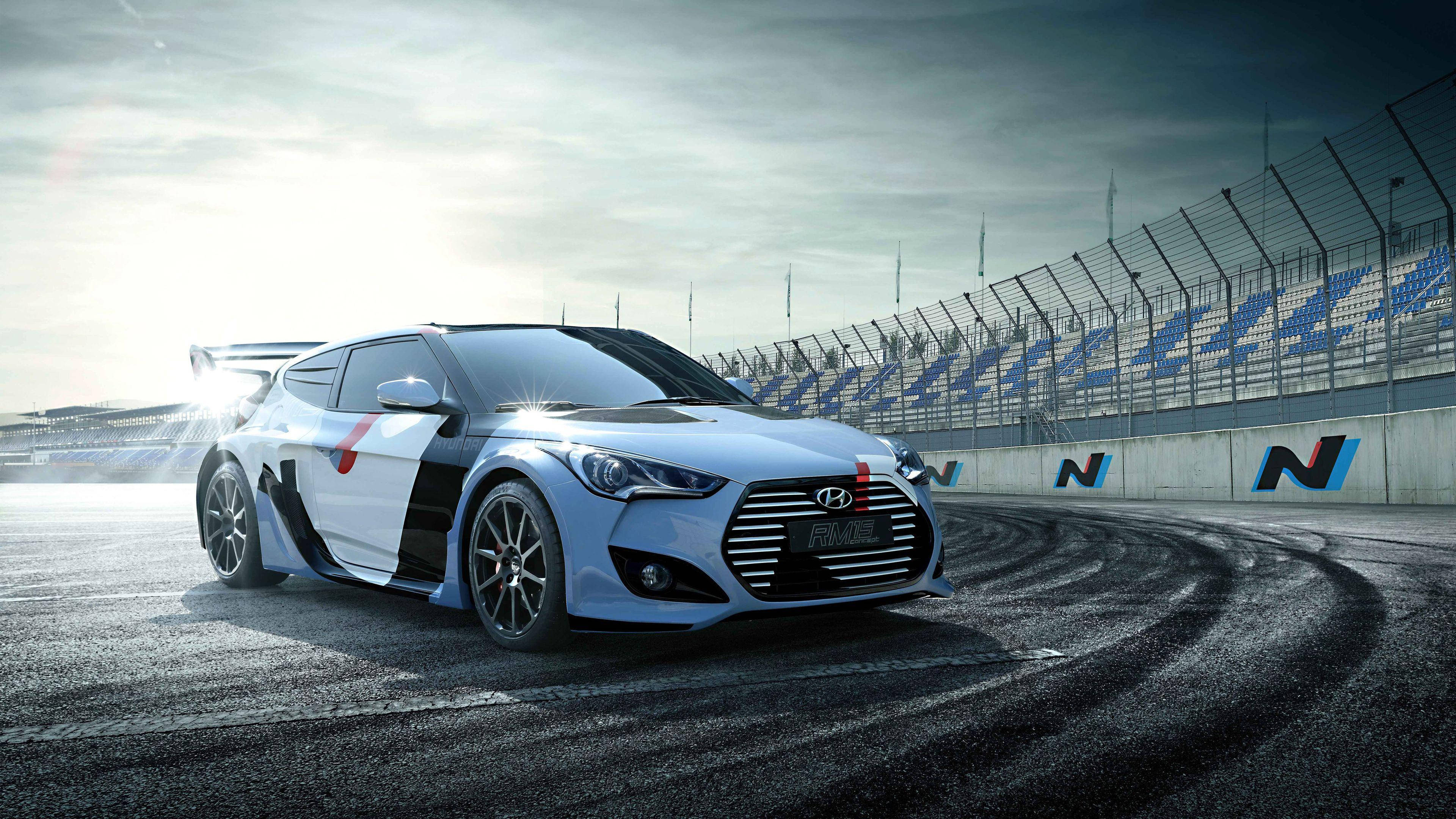 Hyundai 桌布 壁紙 — 一輛時尚的銀色現代Veloster N在陰天下的賽道上飄移，伴隨著輪胎煙霧。