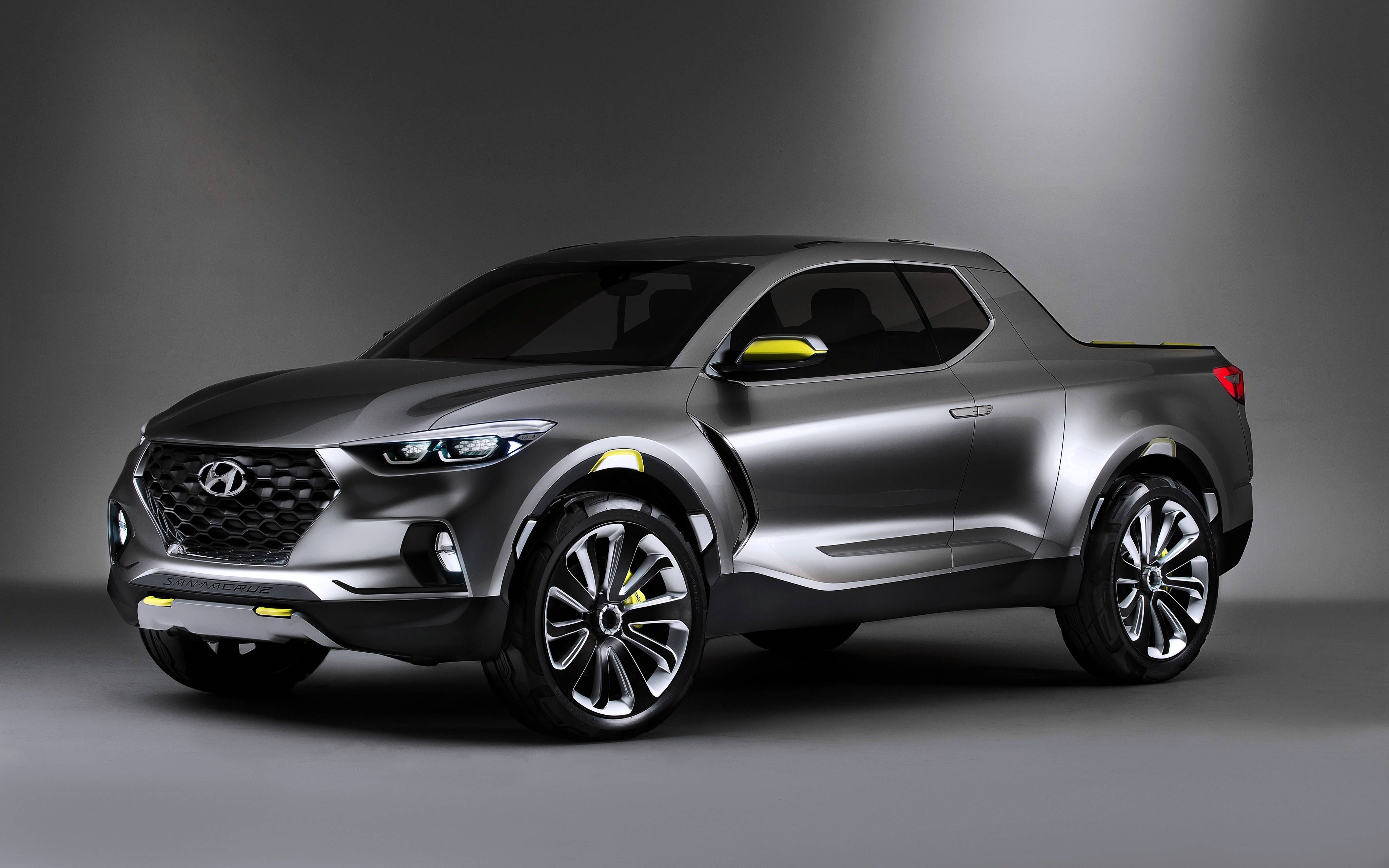 Hyundai 桌布 壁紙 — 一輛時尚的銀色現代概念皮卡車帶有黃色點綴，在戲劇性照明的攝影棚中展示。