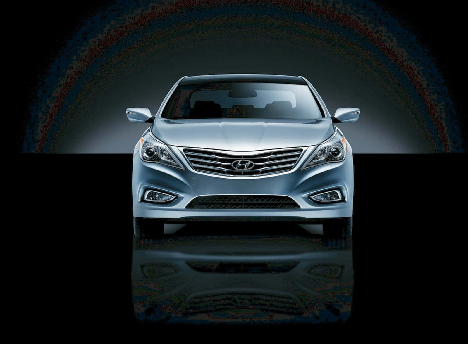 Hyundai Azera 桌布 壁紙 — 一輛時尚的銀色現代轎車位於色彩繽紛的光拱下，下方有光澤的倒影，背景為深色。