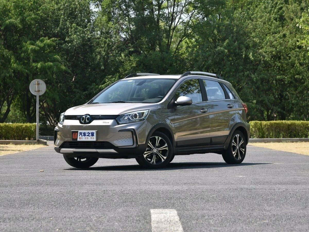 Baic Group 桌布 壁紙 — 一輛時尚的銀色緊湊型SUV停在柏油路上，背景是茂密的綠色樹木，光線明亮。