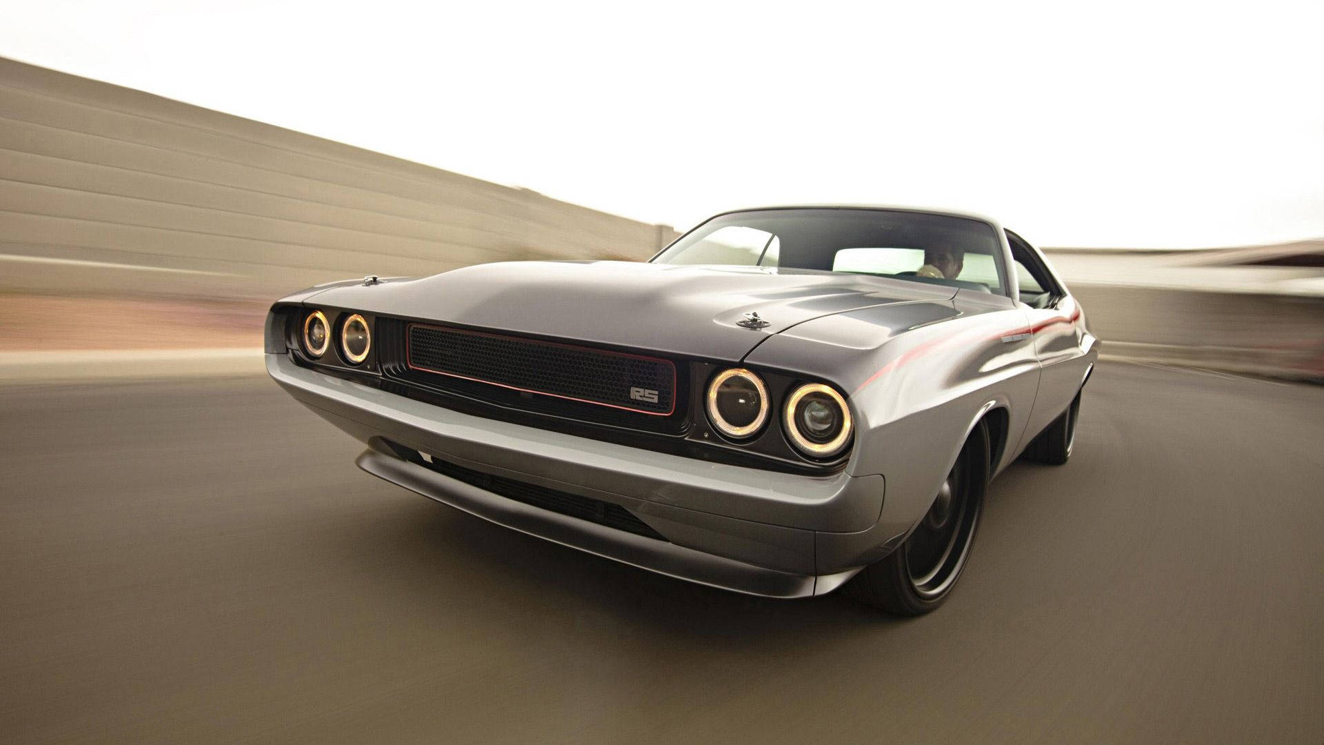 Dodge 桌布 壁紙 — 一輛時尚的銀色肌肉車，帶有發光的圓形頭燈，在模糊的混凝土道路上疾馳。