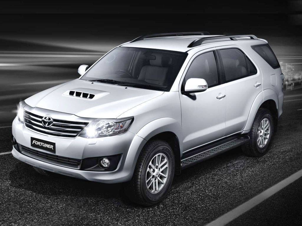Toyota 桌布 壁紙 — 一輛時尚的銀色豐田 Fortuner SUV 在黑暗的道路上行駛，背景帶有動態模糊條紋。