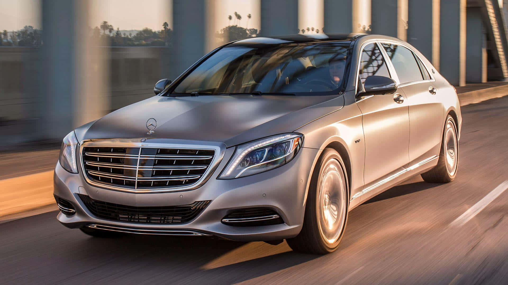Maybach 桌布 壁紙 — 一輛時尚的銀色賓士S-Class轎車在黃金時段平穩地滑行於現代橋樑下。