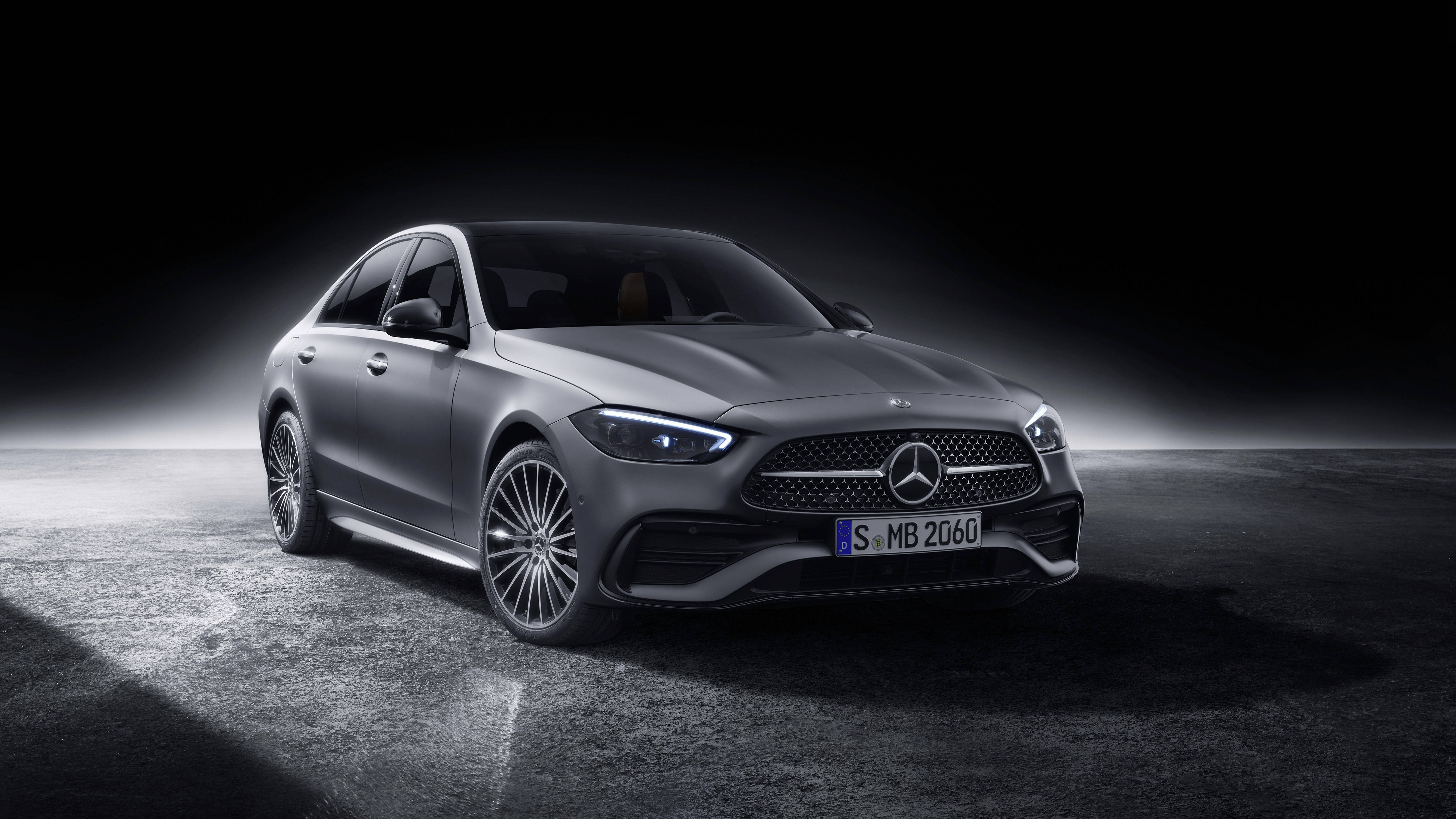 Mercedes Benz C300 桌布 壁紙 — 一輛時尚的銀色賓士轎車在戲劇性的聚光燈下，在帶有紋理混凝土地板的黑暗工作室背景前閃閃發光。