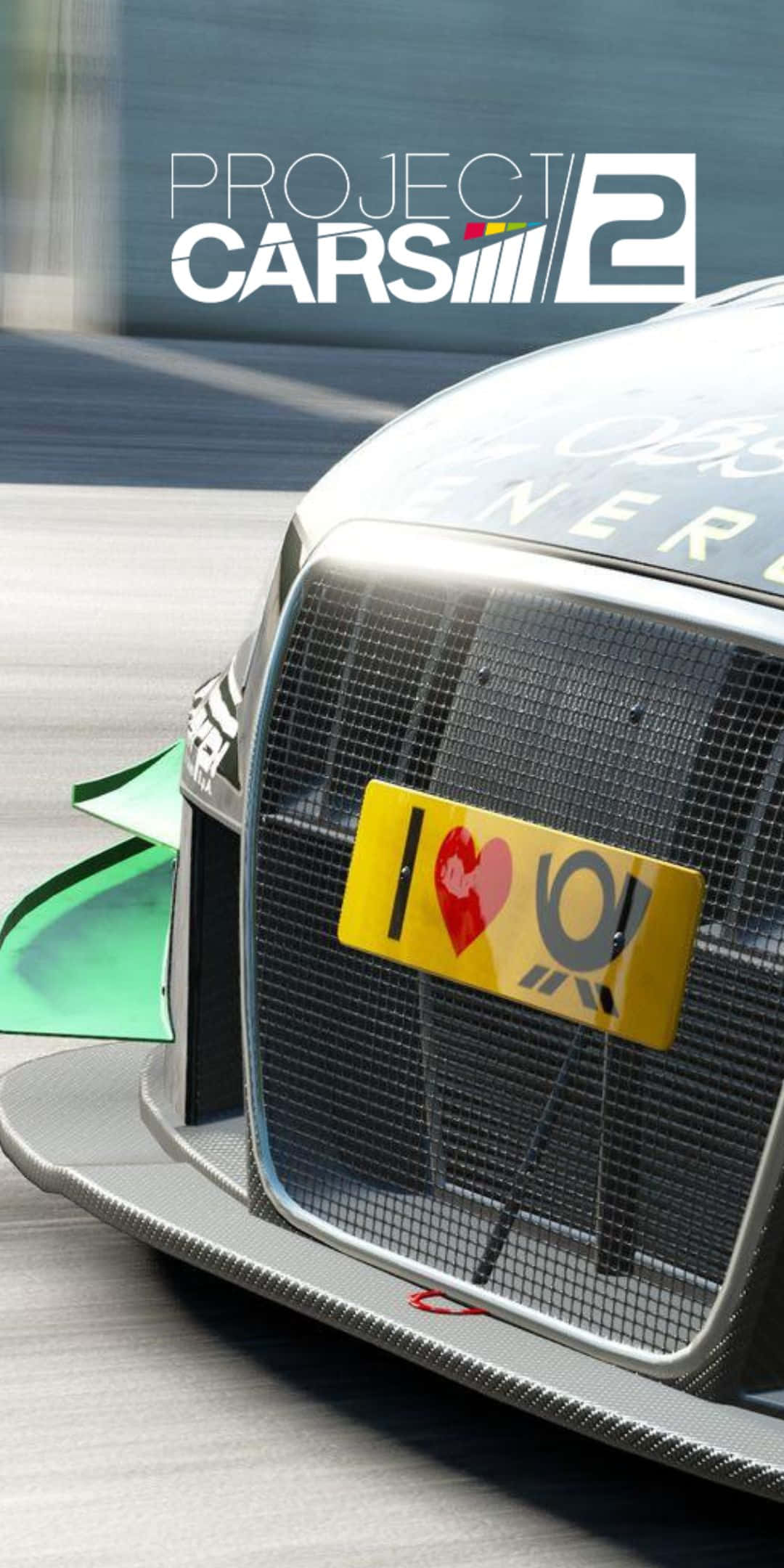 Pixel 3 Project Cars 2 桌布 壁紙 — 一輛時尚的銀色賽車，帶有黃色車牌寫著「I ❤️ Q」，在明亮的日光下於賽道上疾馳。