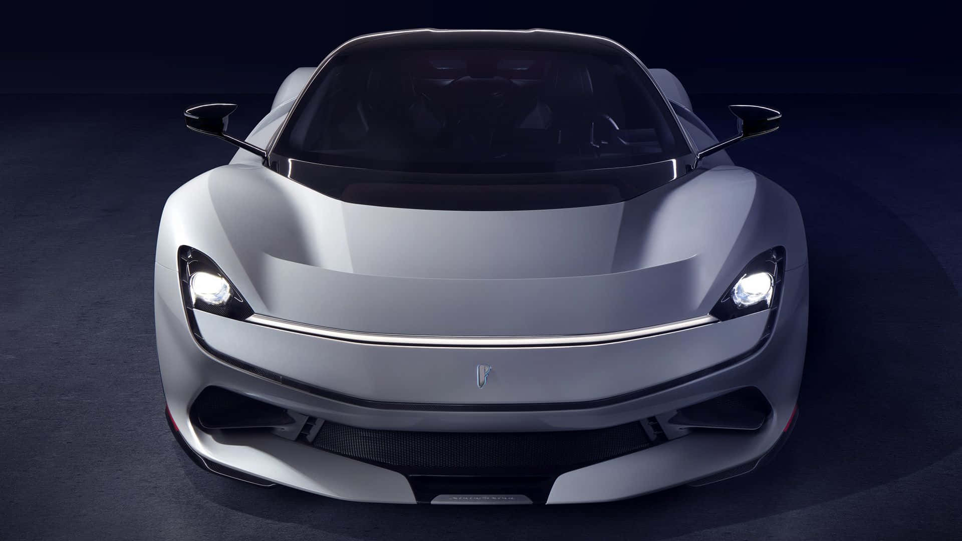 Pininfarina 桌布 壁紙 — 一輛時尚的銀色跑車，帶有發光的車頭燈，在黑暗的攝影棚背景下向前凝視。