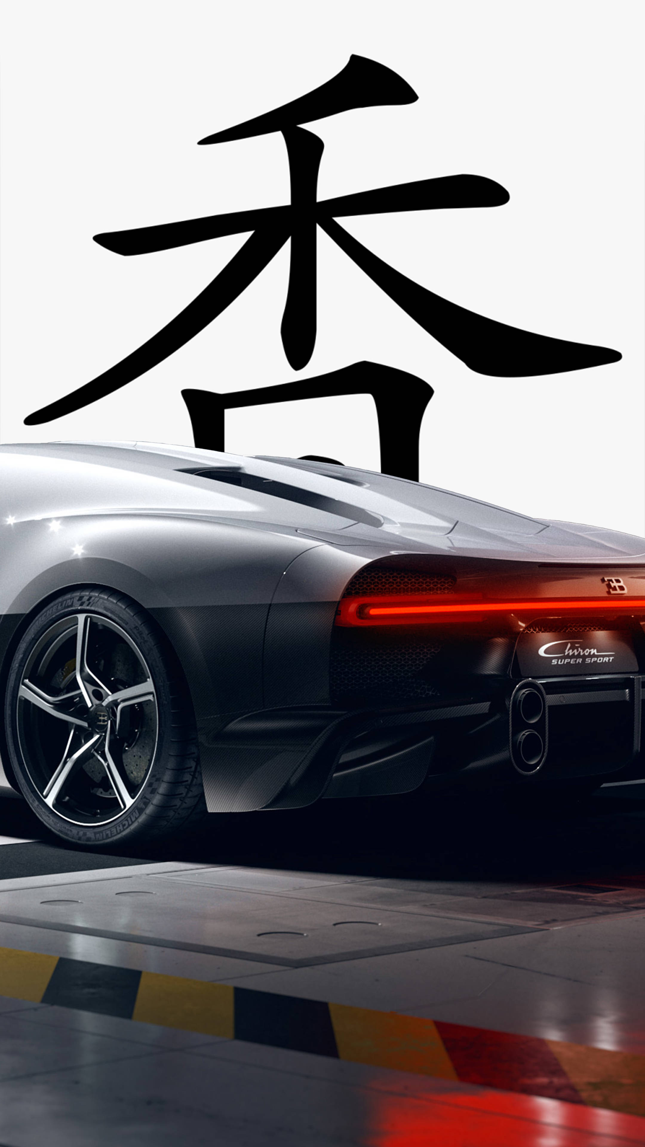 黑色 桌布 壁紙 — 一輛時尚的銀色跑車，紅色尾燈發光，停放在反光地板上一個大型黑色中文字下方。