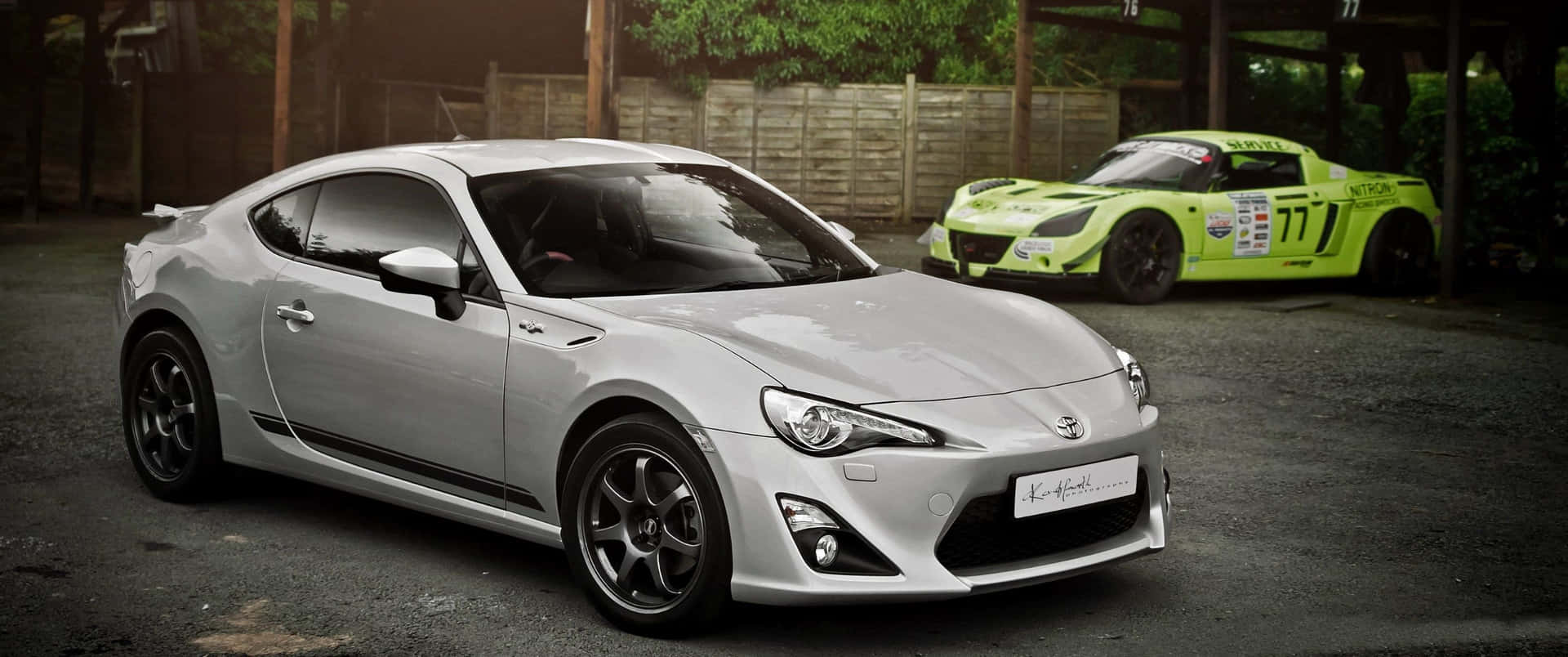 銀色跑車和綠色賽車並排停放在戶外。 — Toyota Supra Mk4 壁紙