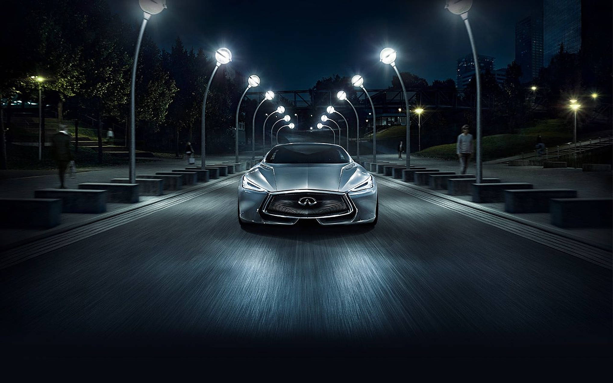 Infiniti 桌布 壁紙 — 一輛時尚的銀色跑車在夜晚閃爍的路燈下，沿著未來主義的城市街道滑行。