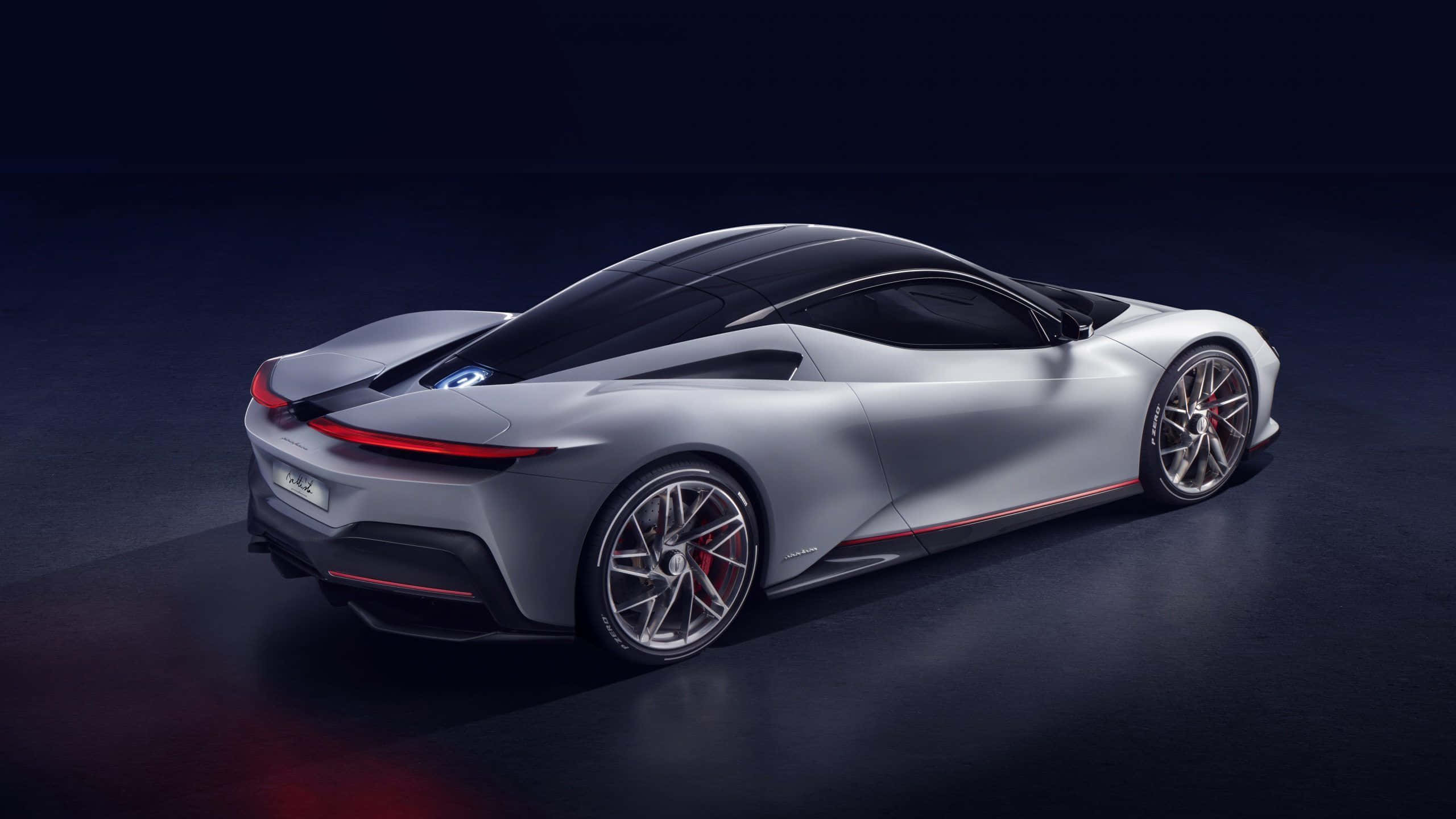 Pininfarina 桌布 壁紙 — 一輛時尚的銀色跑車帶有紅色點綴，在黑暗背景下的工作室燈光中閃耀。