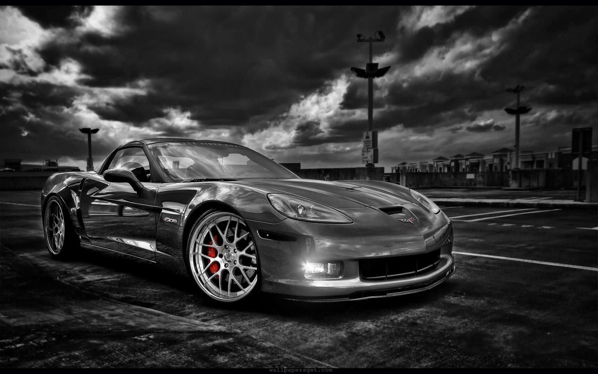 Black And White Car 桌布 壁紙 — 一輛時尚的銀色跑車配備紅色制動卡鉗，停泊在荒涼的停車場，背景是戲劇性的暴風雨天空。