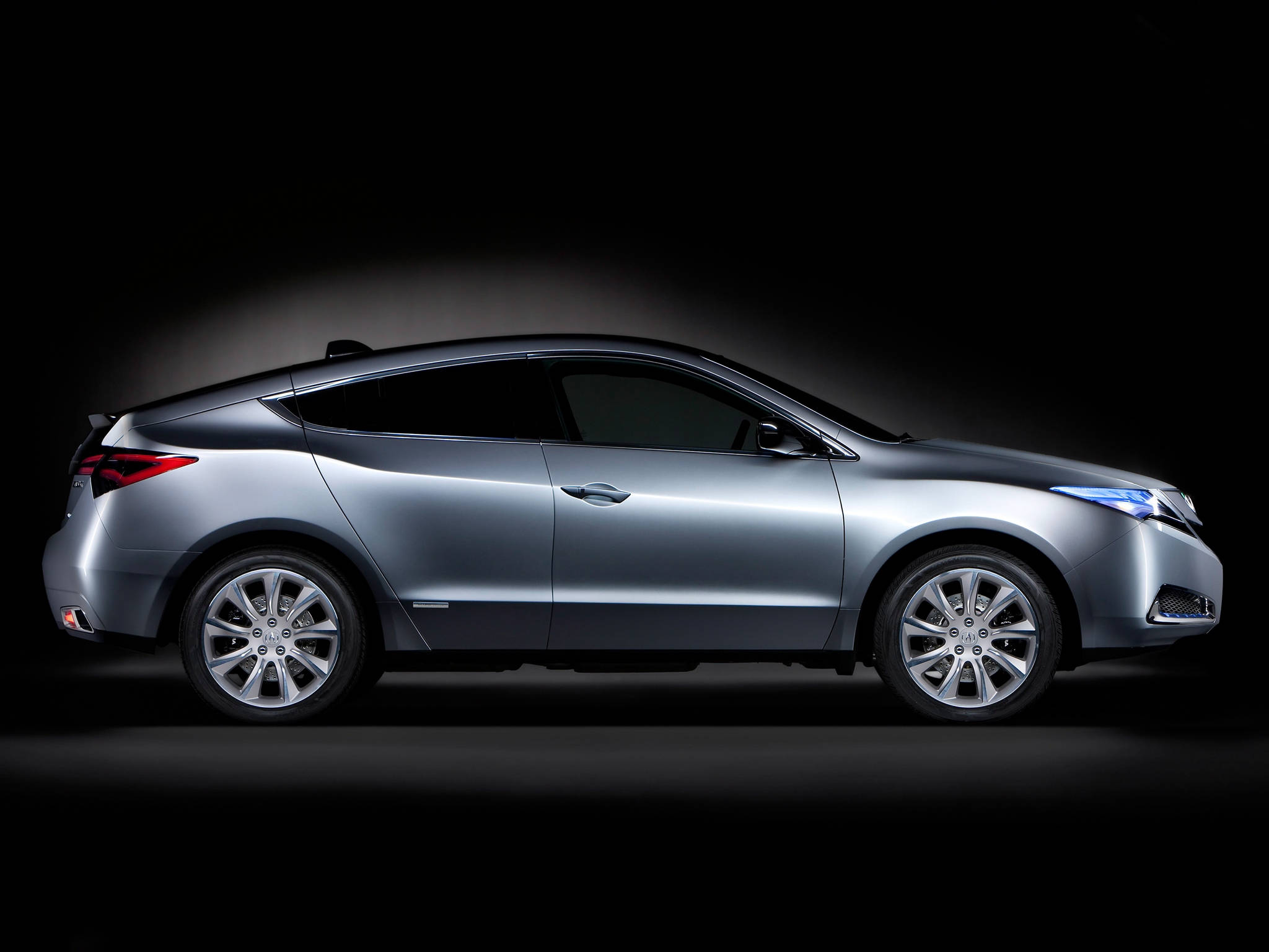 Acura 桌布 壁紙 — 一輛時尚的銀色轎跑車在純黑背景下於攝影棚燈光中閃耀，展示其空氣動力學曲線和合金輪圈。