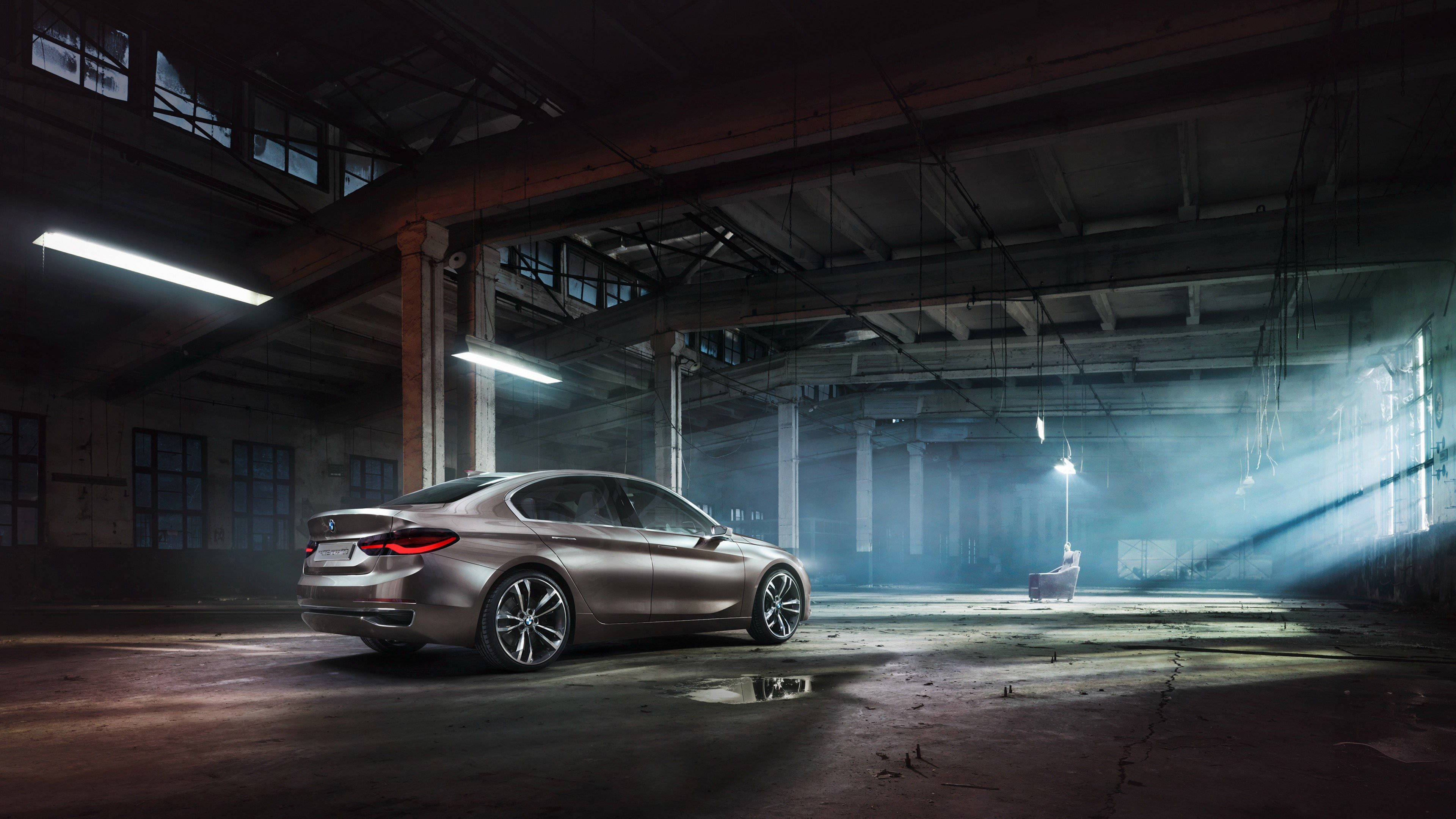 4K BMW 壁紙 桌布 壁紙 — 一輛時尚的銀色轎車在塵土飛揚的廢棄倉庫中，於刺眼的螢光燈下閃耀，破碎窗戶中透入戲劇性的陽光光束。