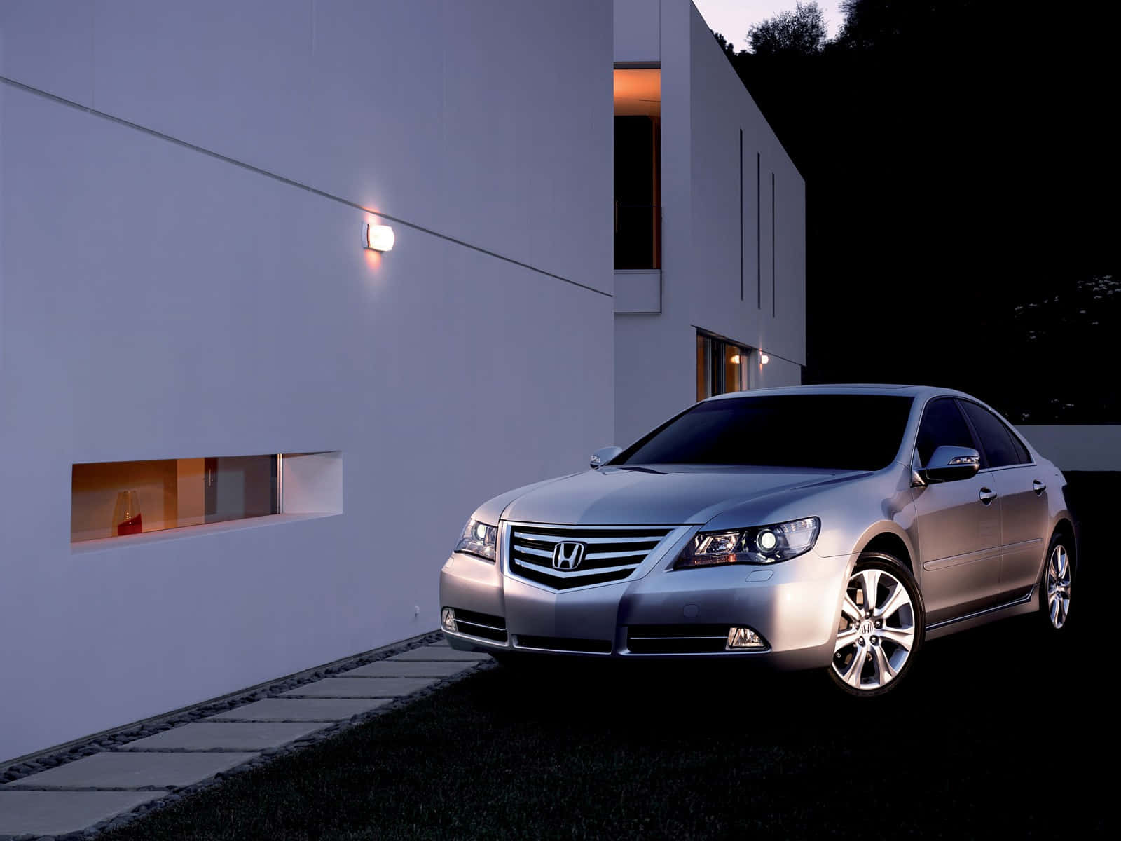 Honda Legend 桌布 壁紙 — 一輛時尚的銀色轎車在黃昏時停在一棟帶有發光窗戶的現代白色房屋旁。