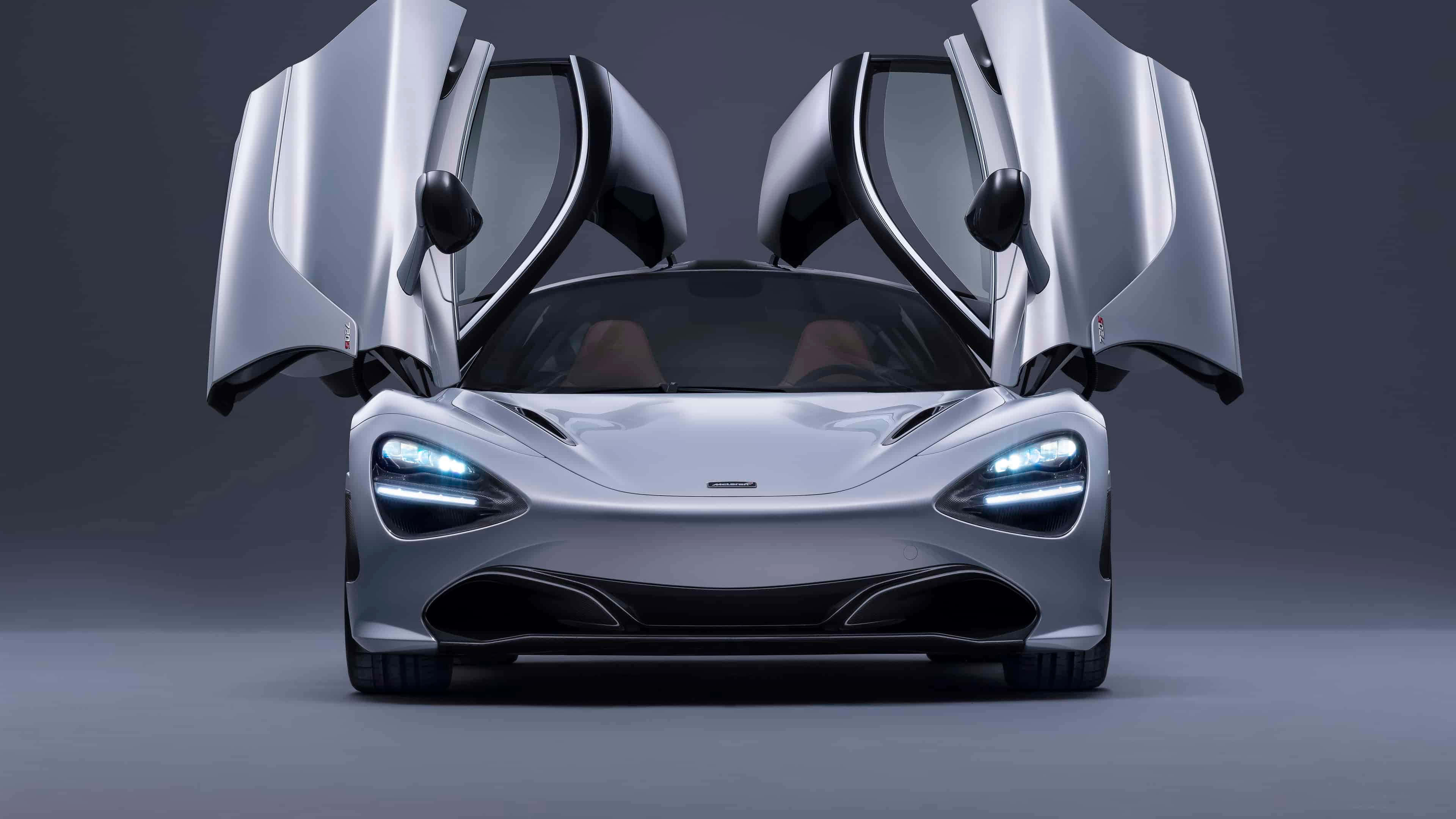 4K Mclaren 720s 桌布 壁紙 — 一輛時尚的銀色麥拿倫跑車，鷗翼門在黑暗的攝影棚背景下敞開。