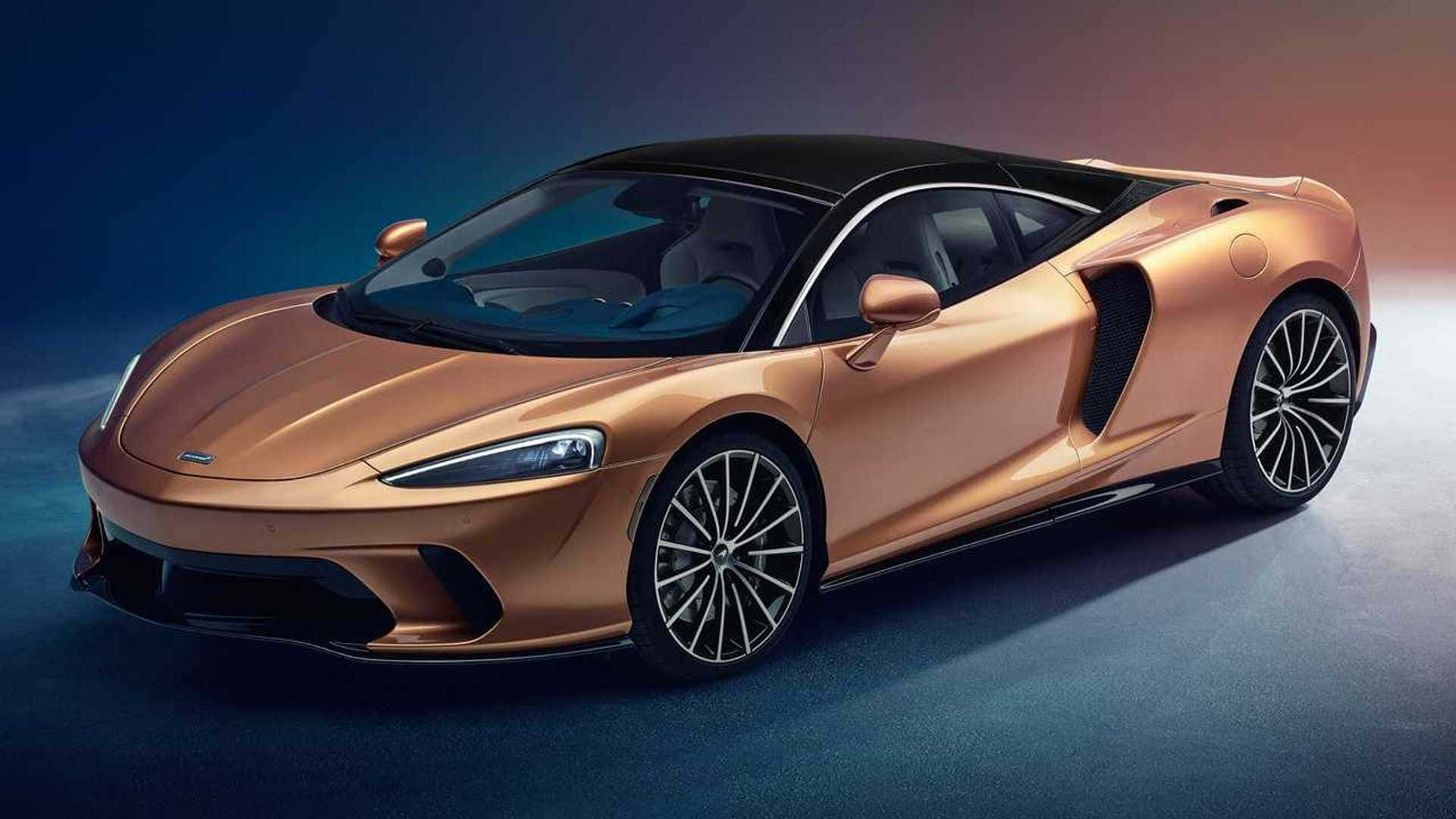 Mclaren Gt 桌布 壁紙 — 一輛時尚的銅色McLaren跑車，配備黑色車頂和車輪，在攝影棚燈光下，以藍橙漸變背景襯托，閃耀光芒。