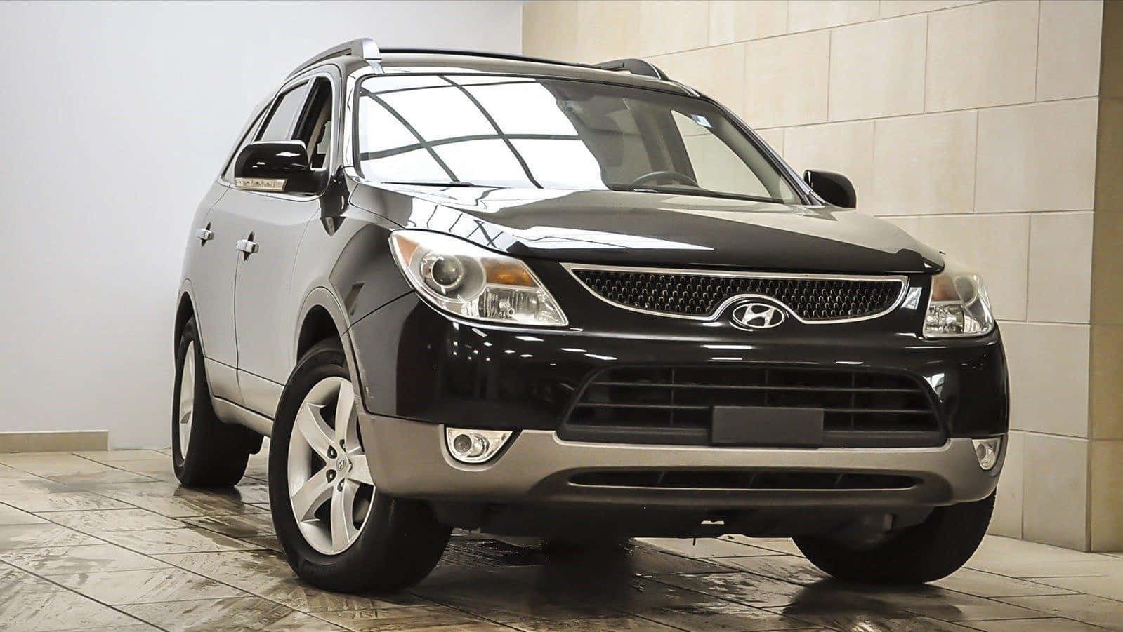 Hyundai Veracruz 桌布 壁紙 — 一輛時尚的雙色Hyundai SUV，黑色引擎蓋和銀色車身，停在室內瓷磚地板上，反射出其拋光的光澤。
