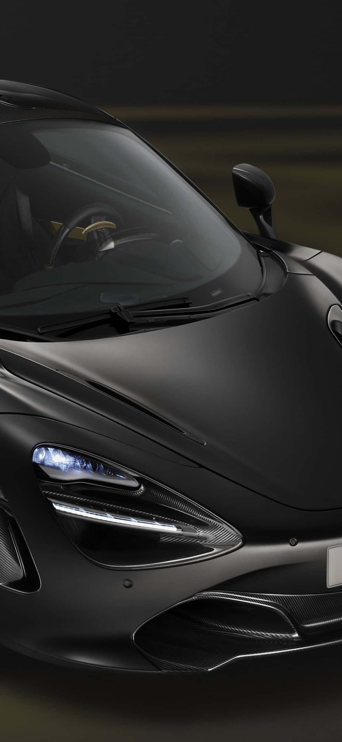 Black Car 桌布 壁紙 — 一輛時尚的霧面黑色跑車，帶有發光的車頭燈和碳纖維飾邊，在戲劇性的低光下拍攝。