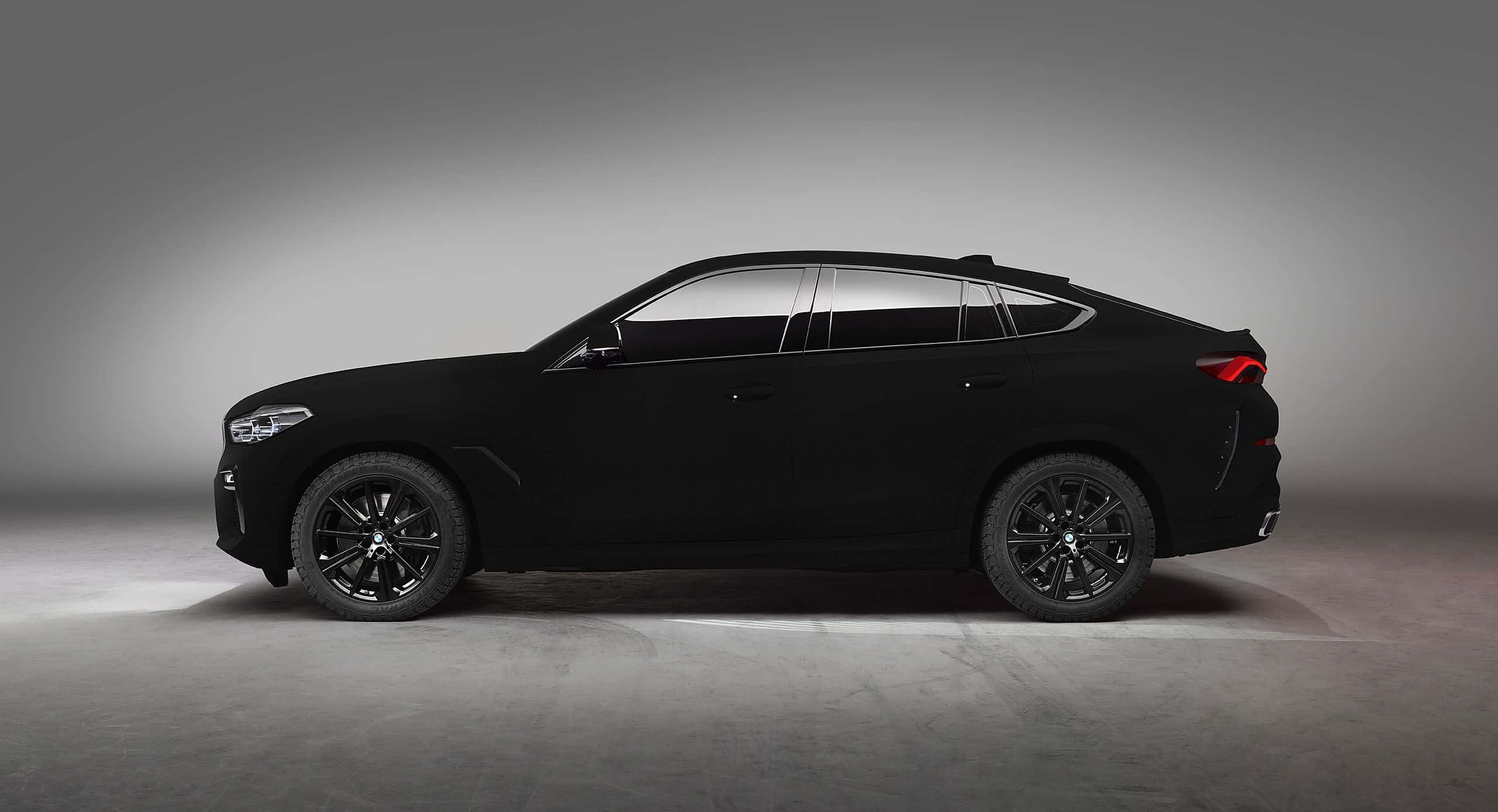 Vantablack 桌布 壁紙 — 一輛時尚的霧黑色BMW X6轎跑SUV，在極簡灰色工作室背景中以側面展示。
