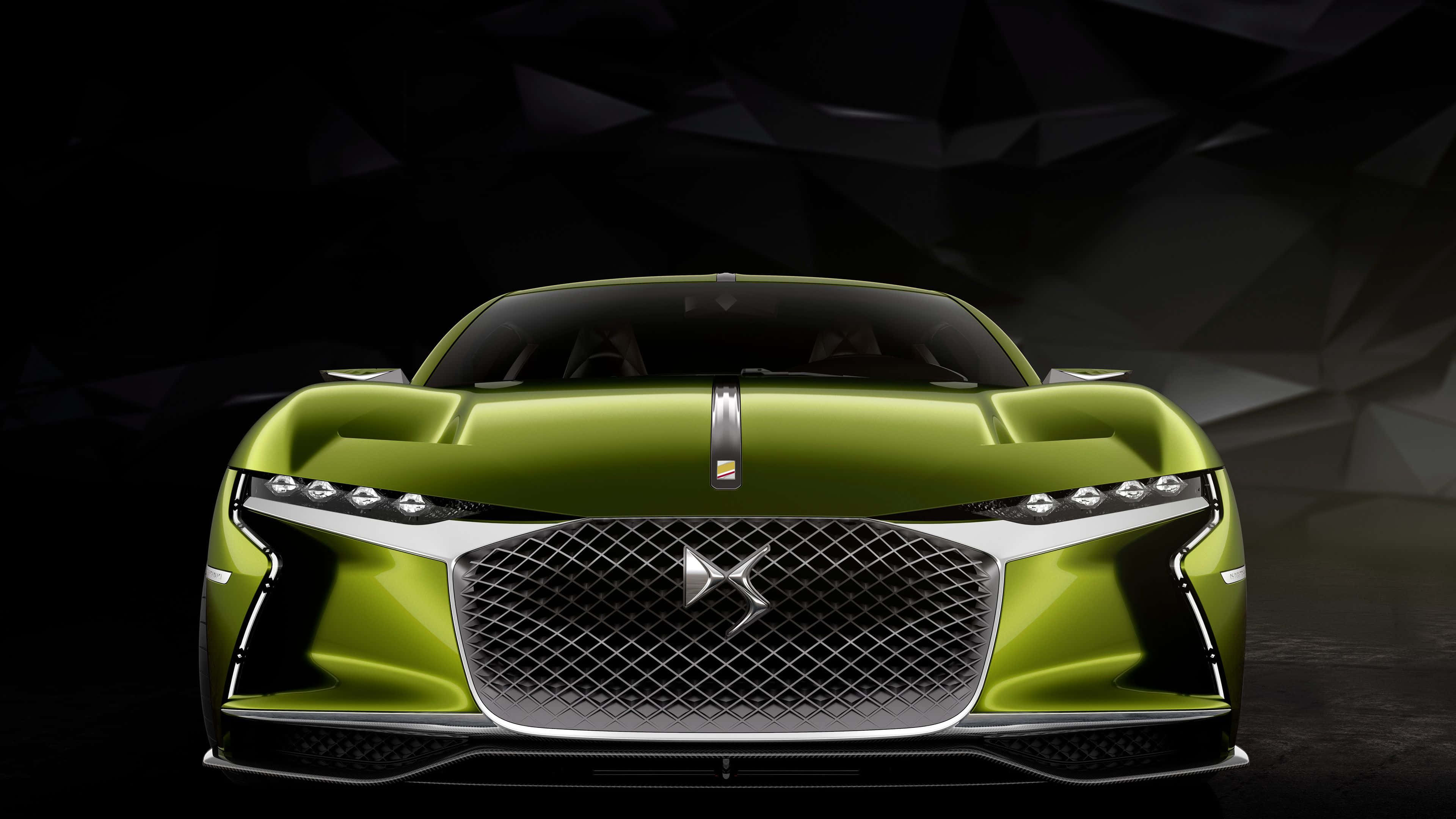 Ds Automobiles 桌布 壁紙 — 一輛時尚的青檸綠色跑車，帶有鍍鉻格柵和鋒利的前燈，在深色幾何背景前凝視前方。