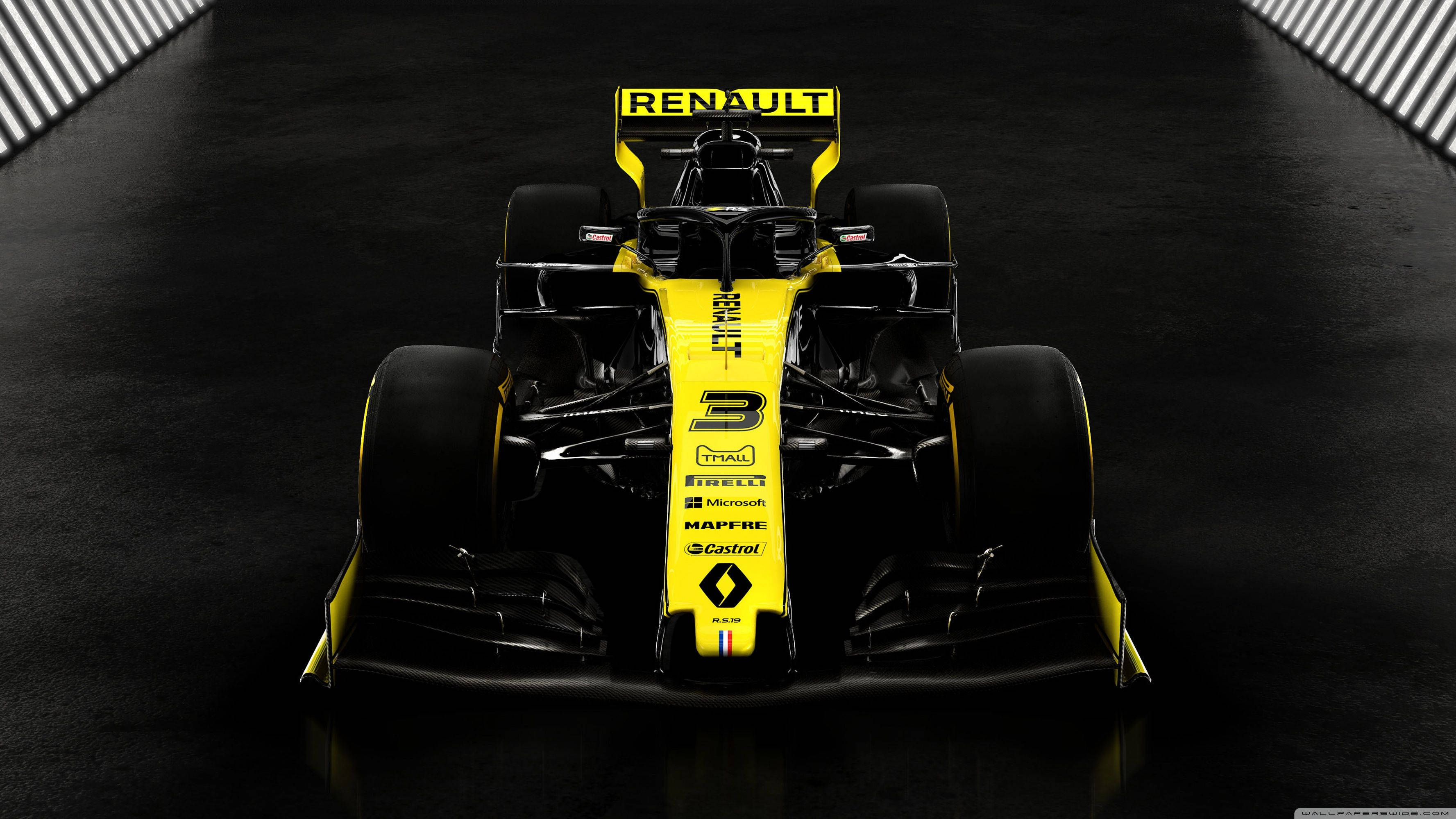 Renault 桌布 壁紙 — 一輛時尚的黃黑雷諾一級方程式賽車在戲劇性燈光下，在黑暗反光賽道上向前行駛。