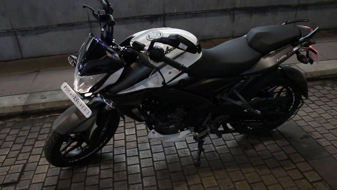 機車 桌布 壁紙 — 一輛時尚的黑白機車停在磚砌路面上，處於人造夜間燈光下。