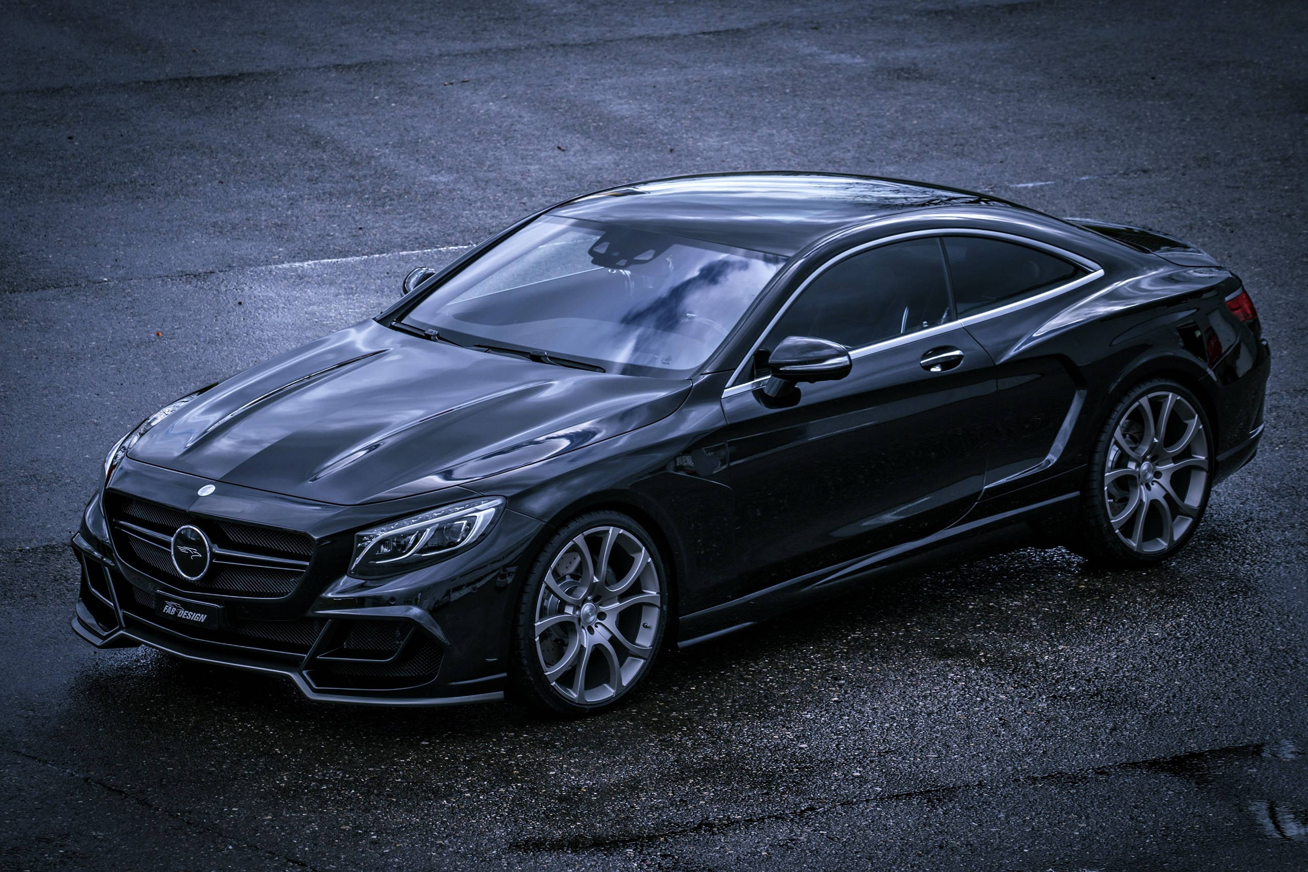 高清 桌布 壁紙 — 一輛時尚的黑色 Mercedes-AMG S65 Coupe 在潮濕的瀝青路面上，在氣氛燈光下閃閃發光。