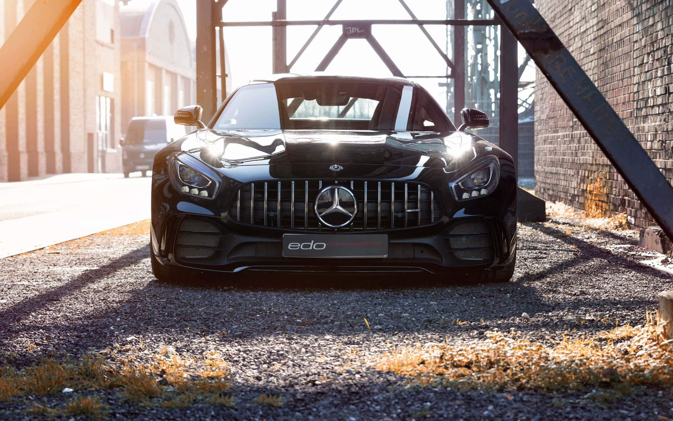 Mercedes 桌布 壁紙 — 一輛時尚的黑色 Mercedes-AMG GT Black Series 停泊在鋼橋下，金色的陽光在礫石上投下長長的影子。