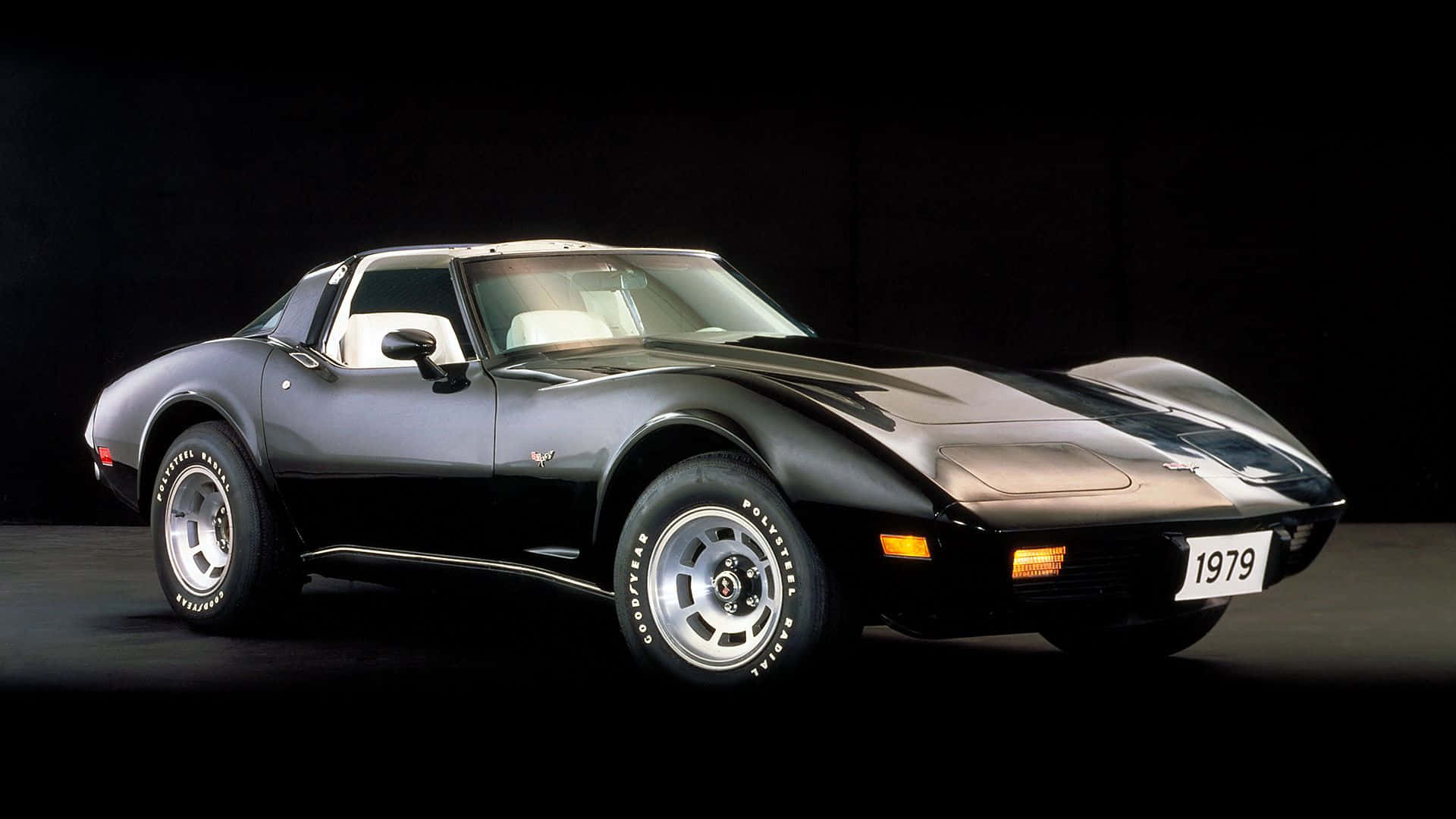 classic 桌布 壁紙 — 一輛時尚的黑色1979年雪佛蘭Corvette跑車，配備白色內裝和銀色輪圈，在深色攝影棚背景下擺拍。