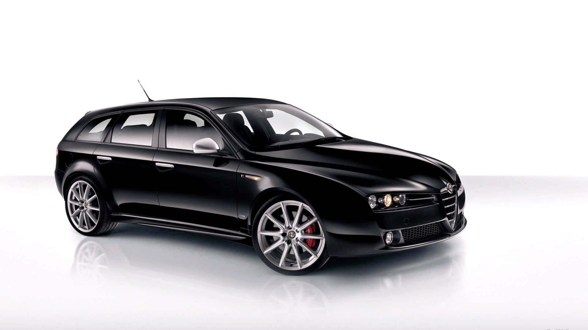 Alfa Romeo 159 桌布 壁紙 — 一輛時尚的黑色Alfa Romeo旅行車在攝影棚燈光下，於反光的白色表面上閃閃發光。