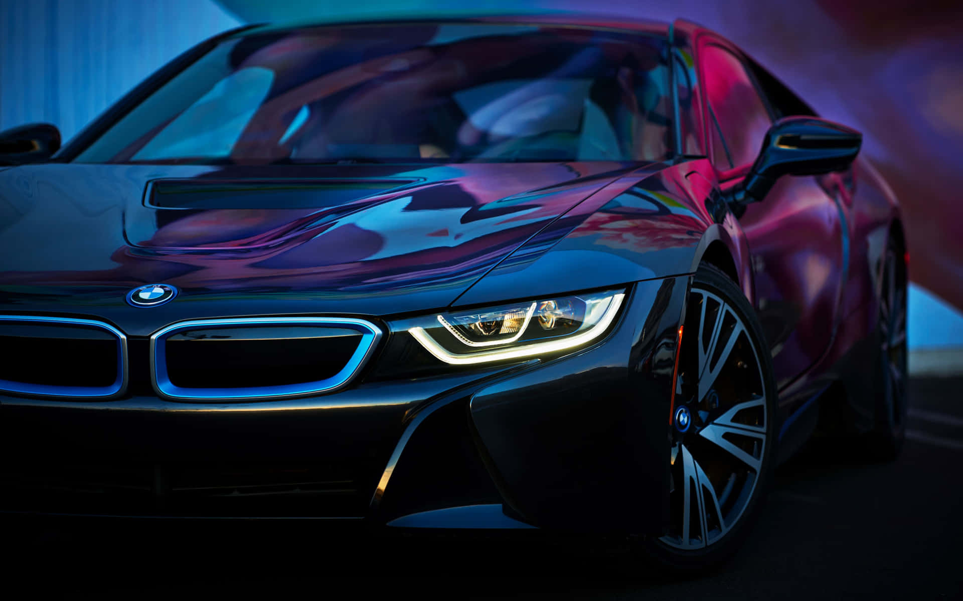 BMW 動圖 桌布 壁紙 — 一輛時尚的黑色BMW i8跑車在黑暗的攝影棚中，在鮮豔的藍色和紫色霓虹燈下閃閃發光。