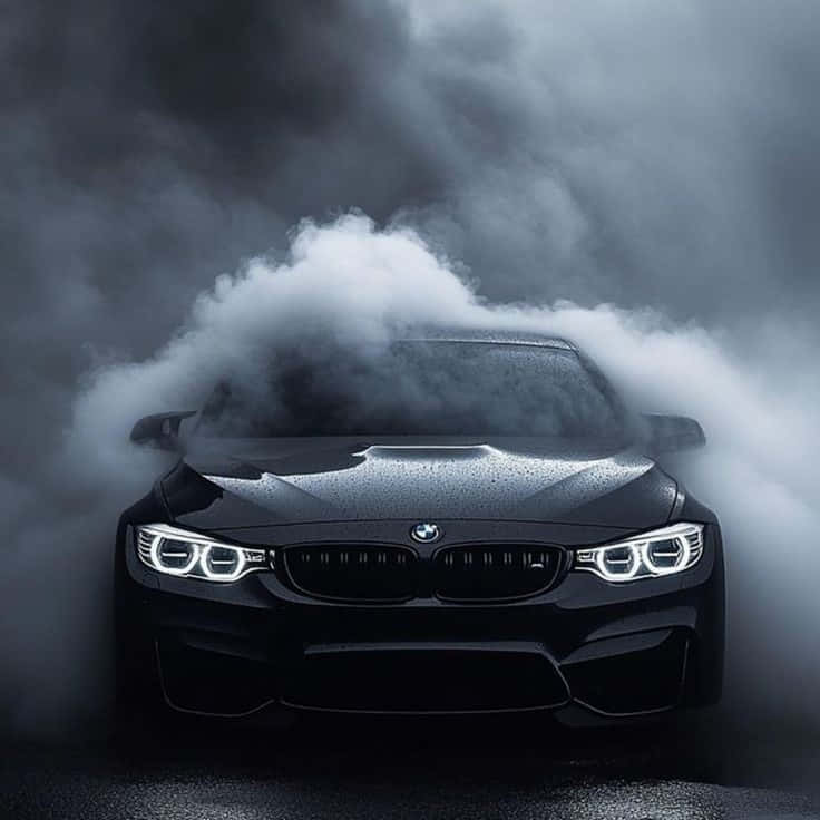 BMW images 壁紙 — 一輛時尚的黑色BMW M4從旋轉的白煙中出現，發光的車頭燈刺穿迷霧般的黑暗。