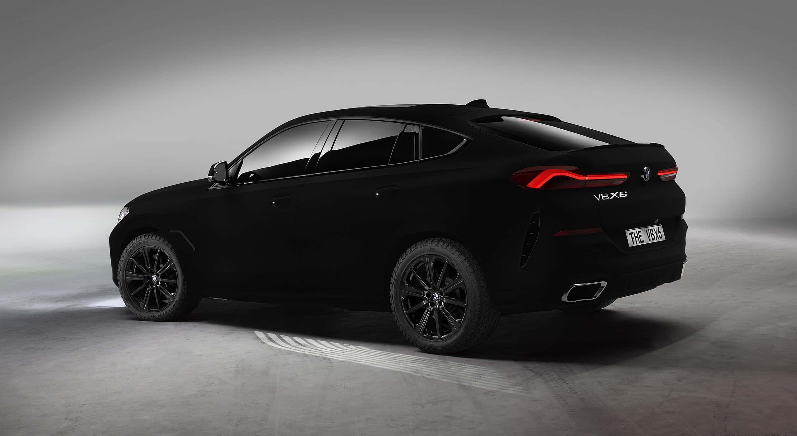 Vantablack 桌布 壁紙 — 一輛時尚的黑色BMW X6 V8X6 SUV在簡約的工作室中展示，帶有發光的紅色尾燈和戲劇性的燈光。