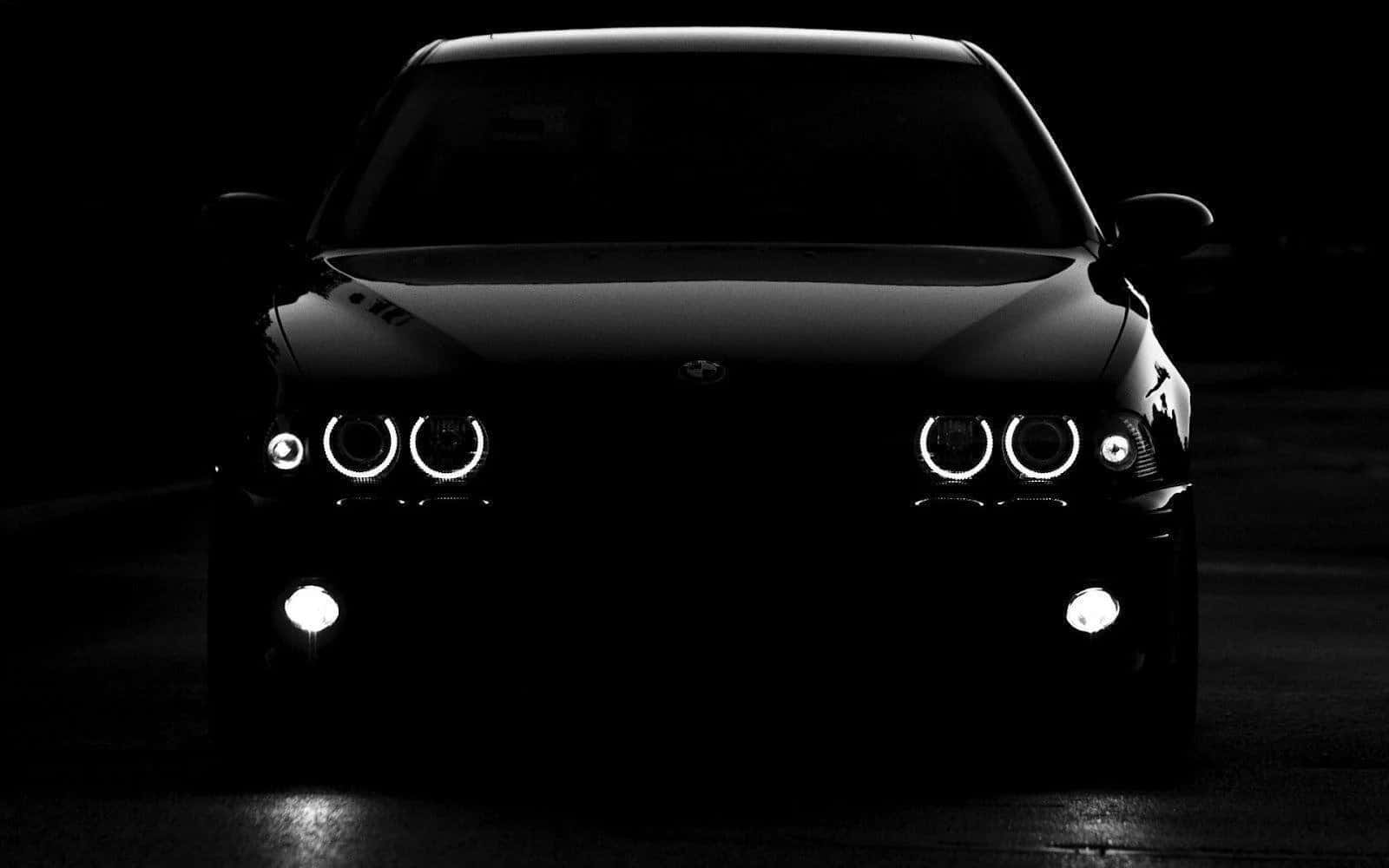 Black Car 桌布 壁紙 — 一輛時尚的黑色BMW汽車在漆黑的夜晚背景下，亮著明亮的圓形車頭燈。