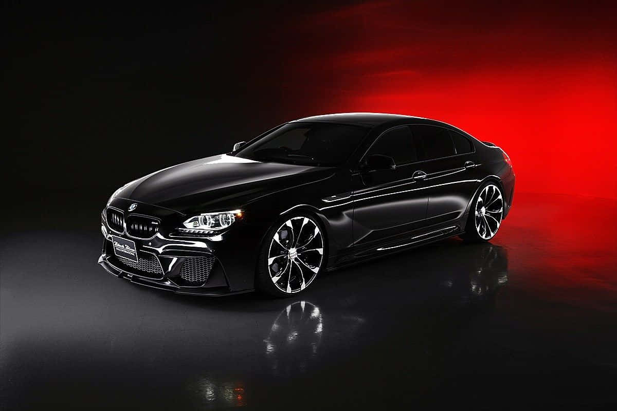 Bmw 6 Series 桌布 壁紙 — 一輛時尚的黑色BMW跑車在戲劇性的紅色工作室燈光下閃耀，地板具有反射效果。